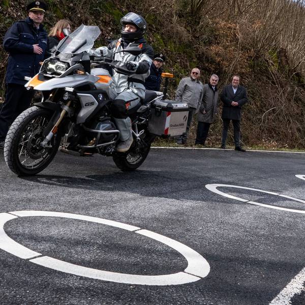 Innenminister Herbert Reul (2.v.r, CDU) und Verkehrsminister Oliver Michael Krischer (r, Bündnis 90/Die Grünen) schauten sich die in Kurven beliebter Motorradstrecken aufgemalten Ellipsen an. Sie sollen verhindern, dass Motorradfahrer die Kurven schneiden.