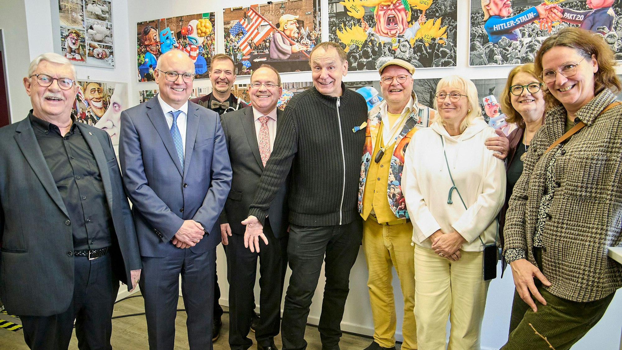 Die oben Genannten stehen nebeneinander, im Hintergrund hängen Bilder, die Tilly gemalt hat.