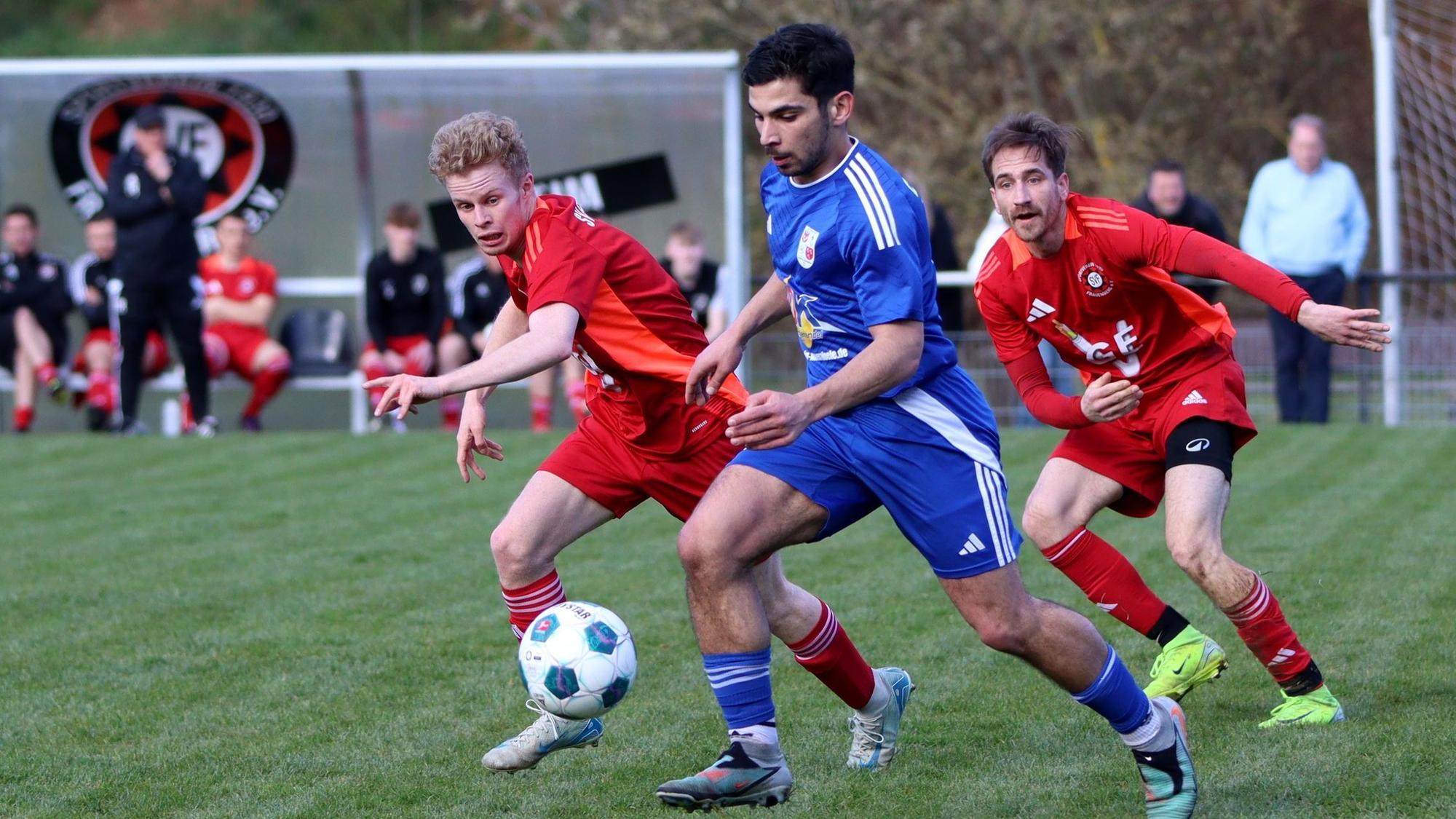 Das Bild zeigt Silvio Ferjani, der an Frauenbergs Jan Tornow (l.) und Marcel Motz vorbeigeht.