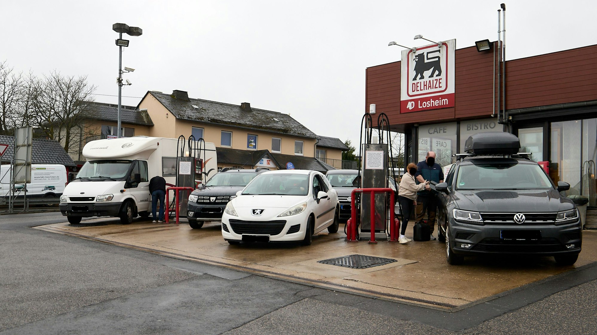 Autos stehen in vier Reihen an den Zapfsäulen.
