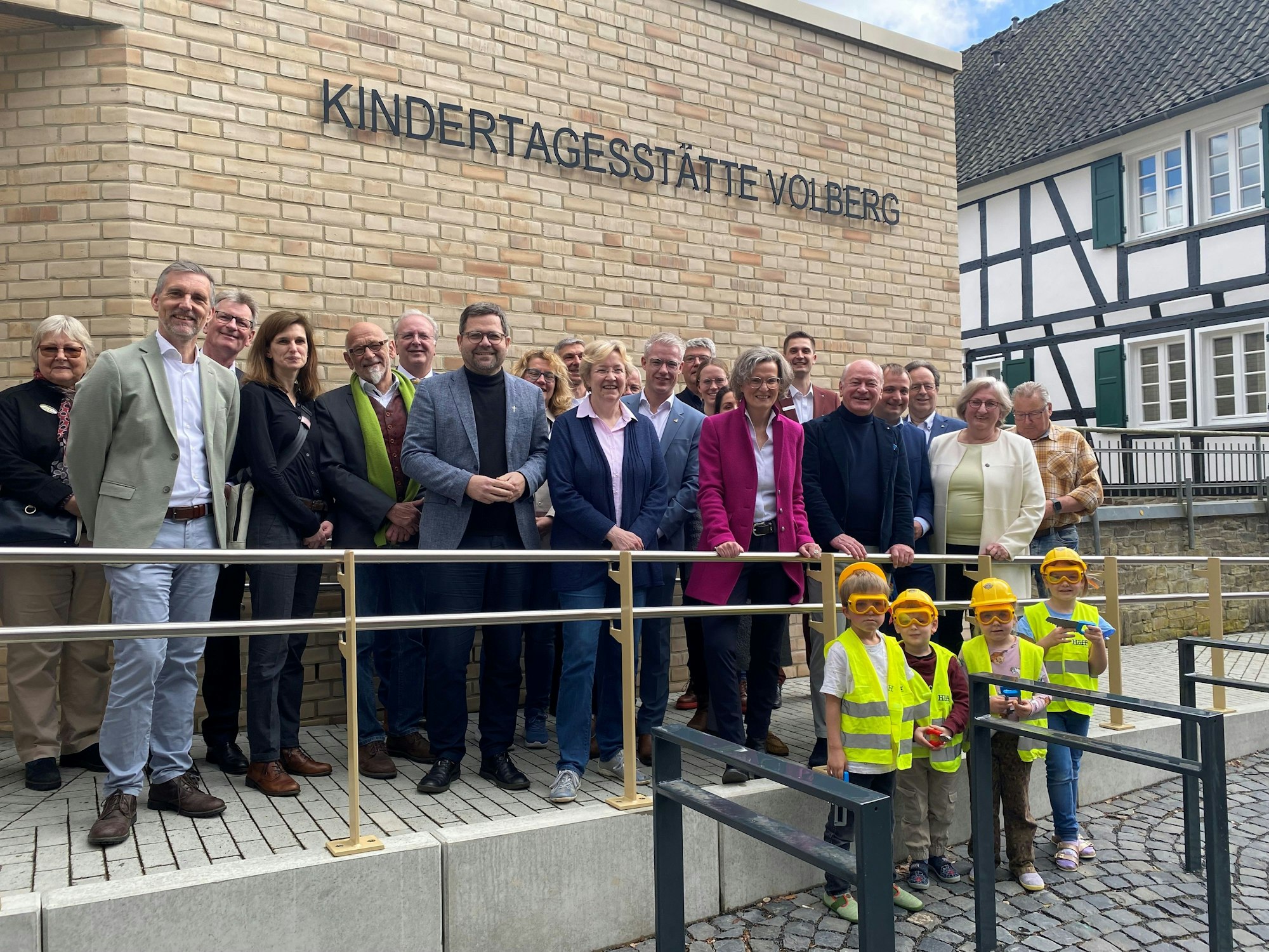 eine große Gruppe steht vor der Kindertagesstätte