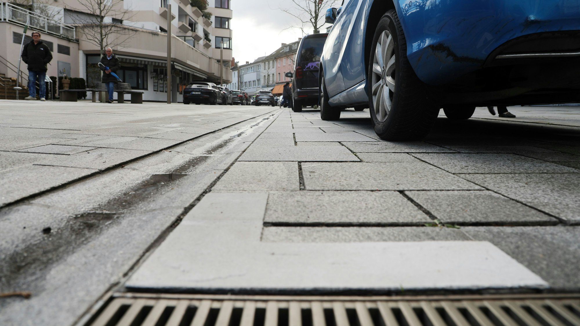 Auf dem Asphalt ist neben einem Autoreifen ein weißer Winkel aufgetragen.