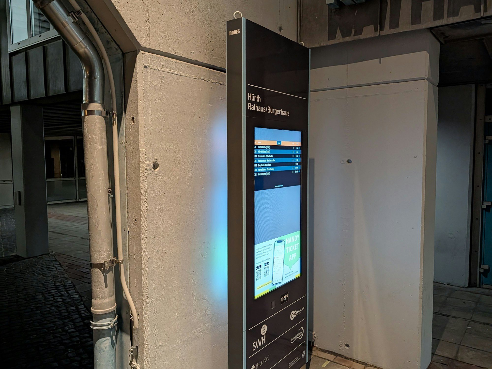 Das Foto zeigt die Stele vor der Wand am Rathaus.