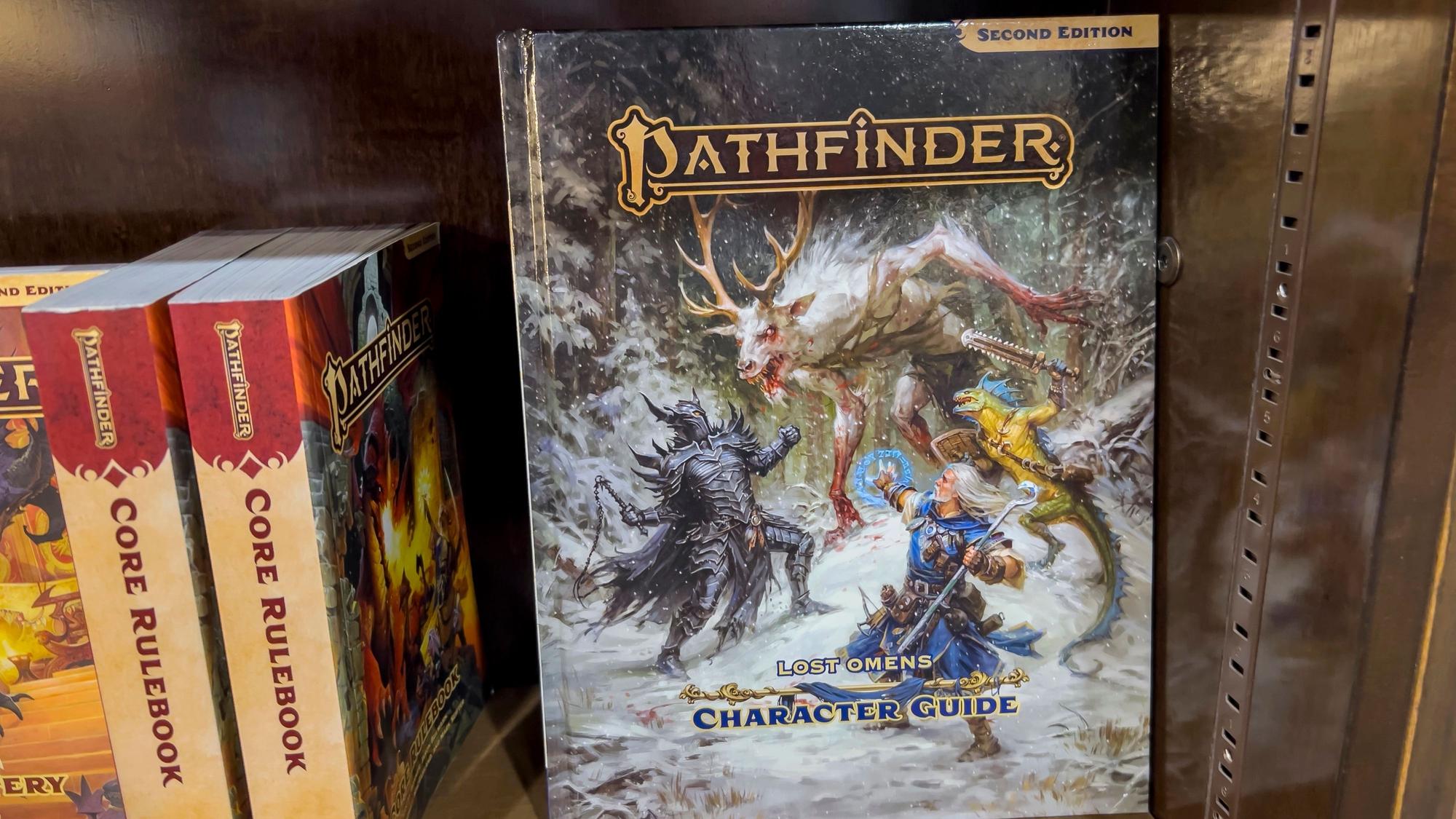 Pathfinder-Charakterführer in einem Buchregal. Auch dieses Rollenspiel wird in Siegburg angeboten.
