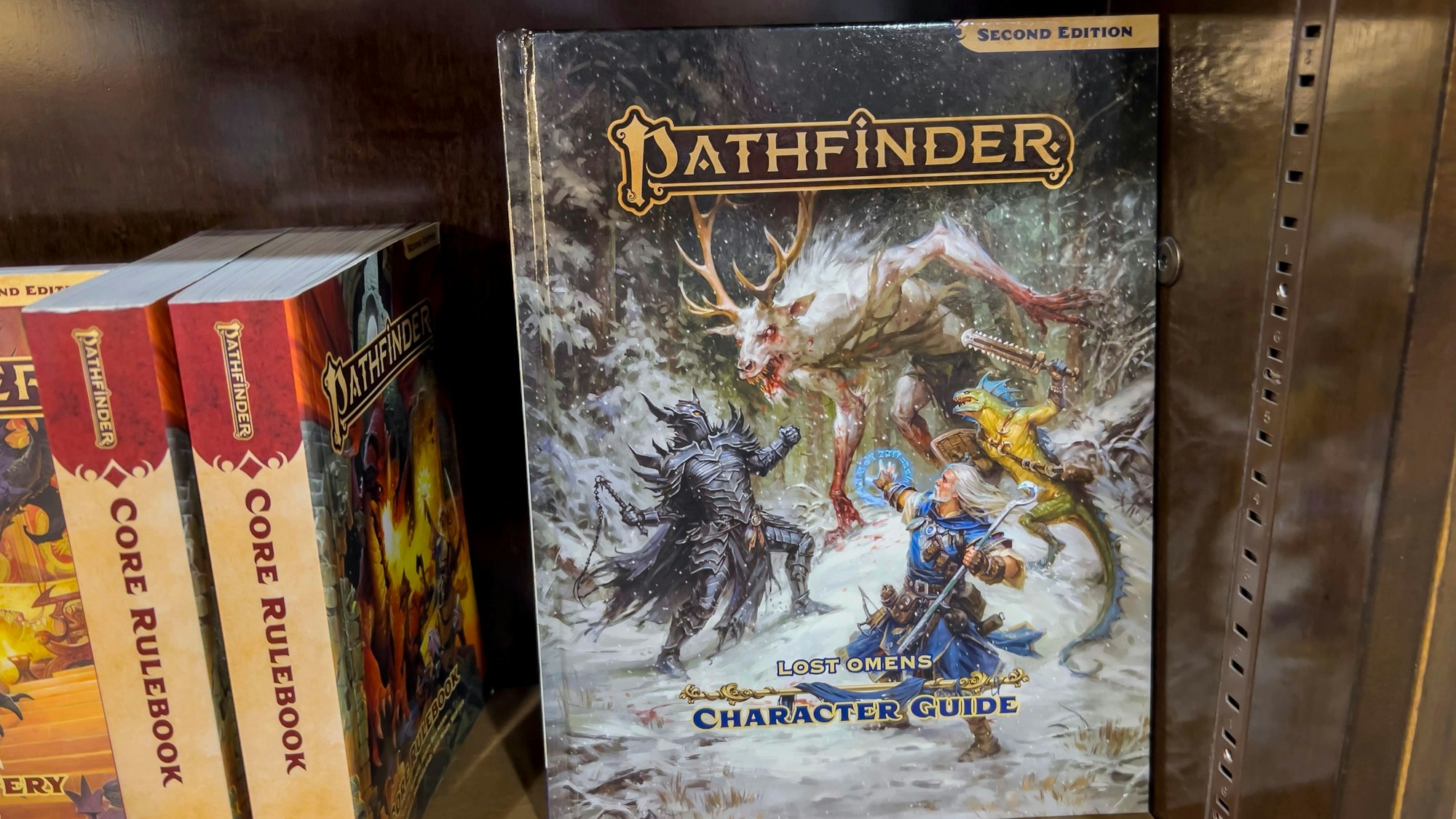 Pathfinder-Charakterführer in einem Buchregal. Auch dieses Rollenspiel wird in Siegburg angeboten.