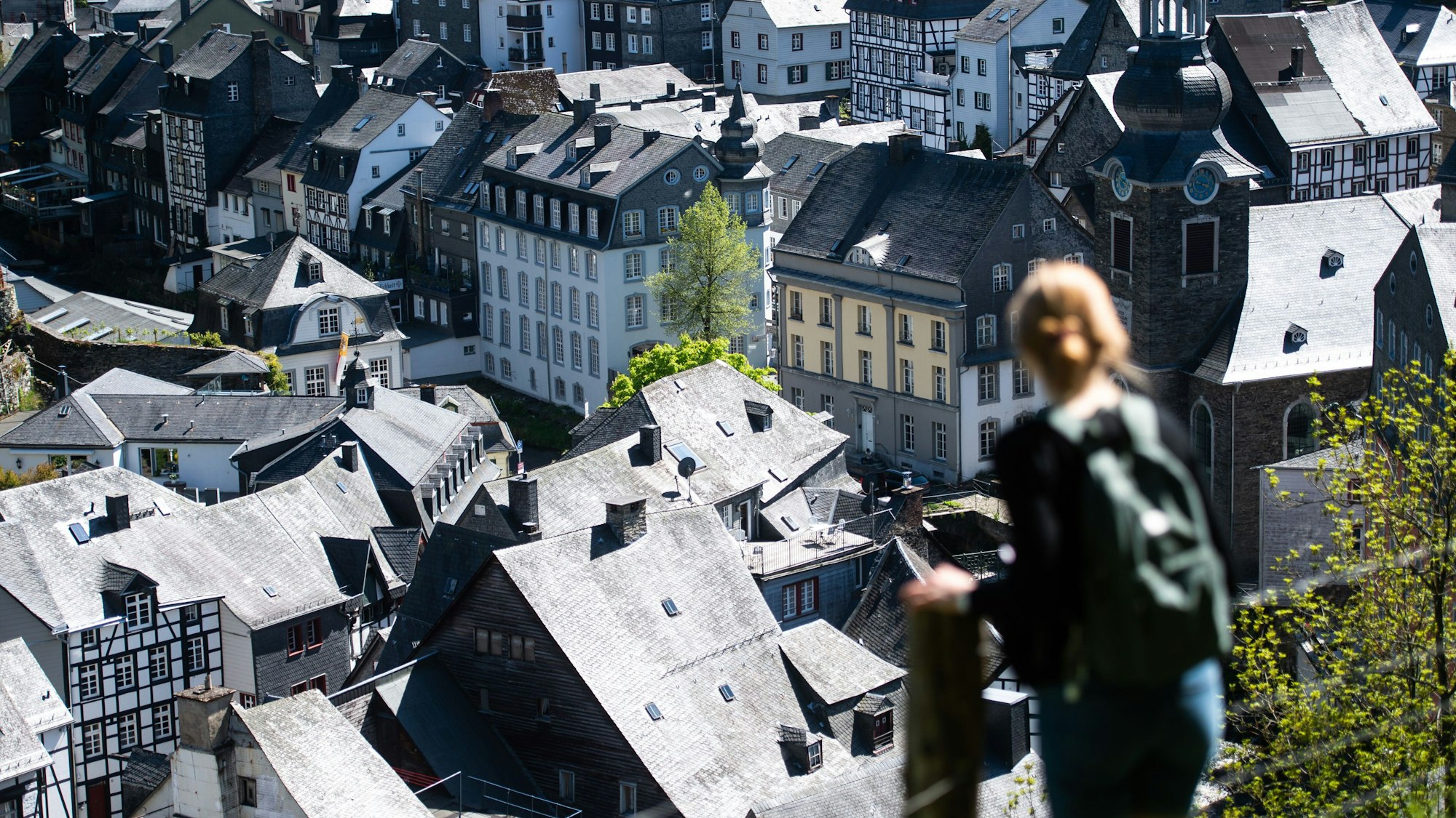 Eine Frau steht auf einem Pfad über den Dächern der Altstadt von Monschau in der Eifel (Symbolfoto).