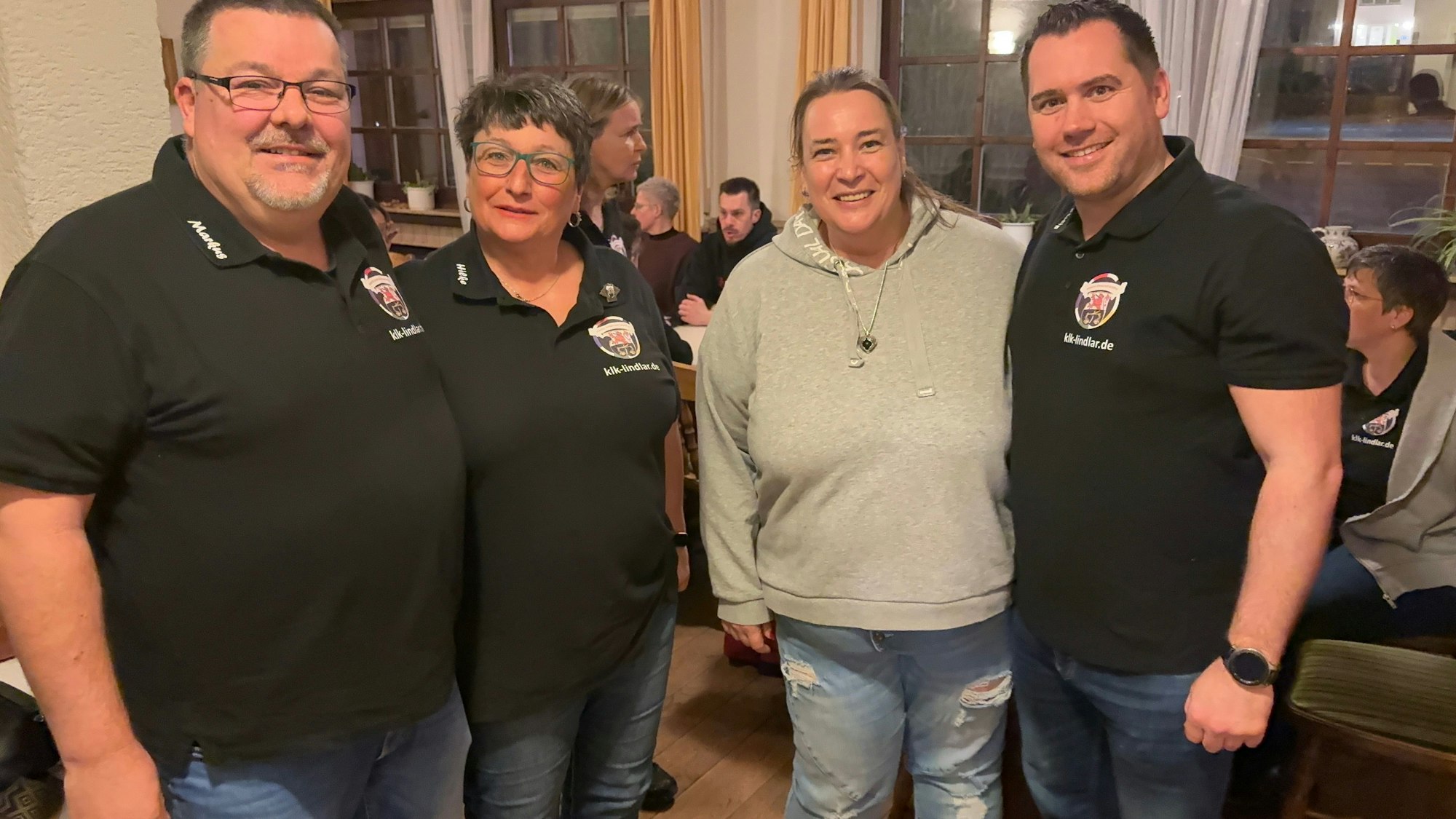 Zwei Frauen und zwei Männer posieren für die Kamera.