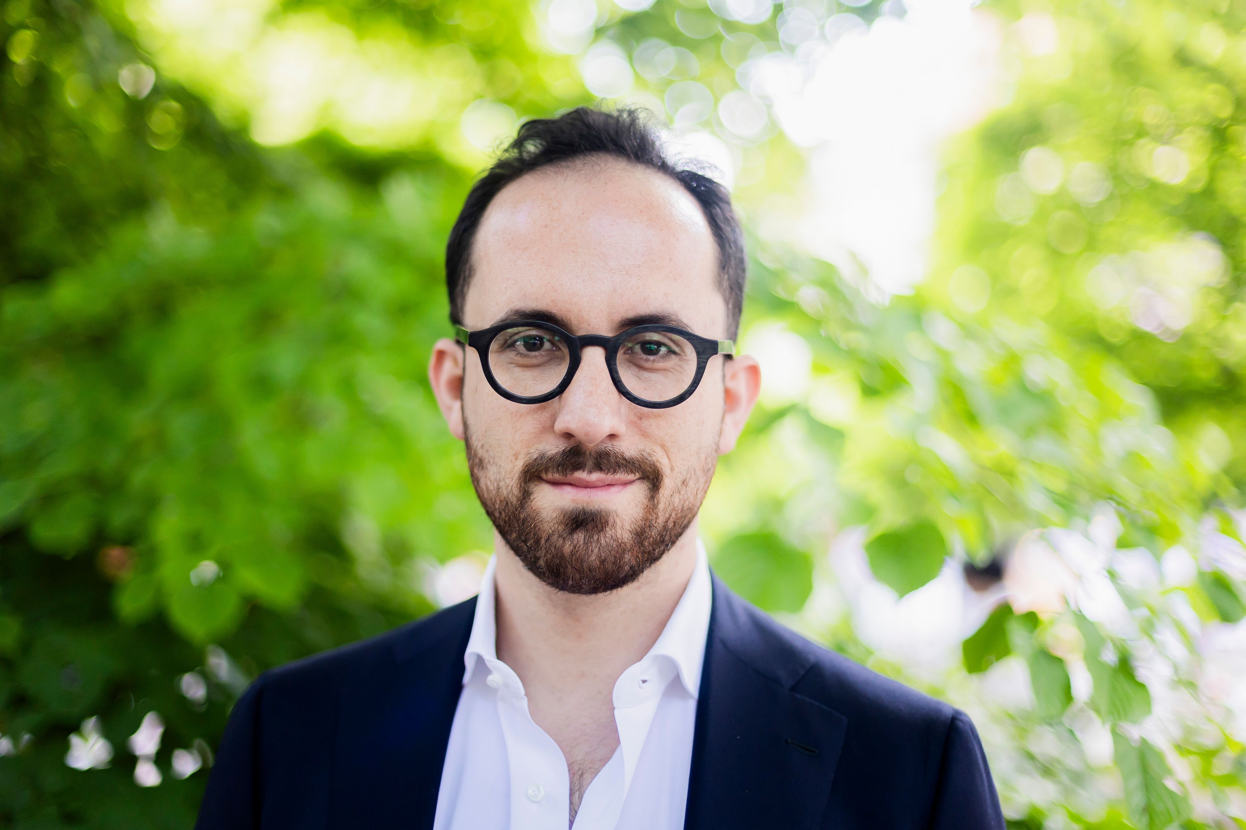 Ein Mann mit Brille blickt freundlich in die Kamera.