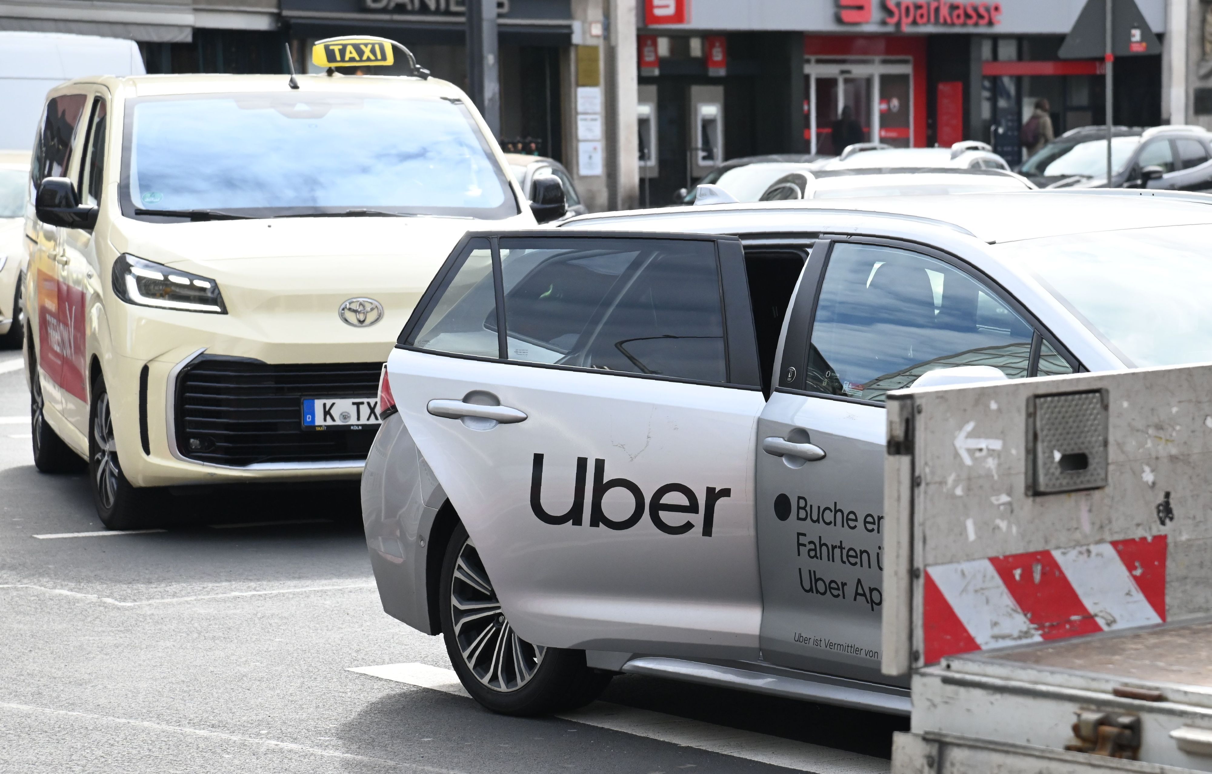 Ein Uber-Fahrzeug nimmt am Kölner Neumarkt einen Fahrgast auf (Archivbild).