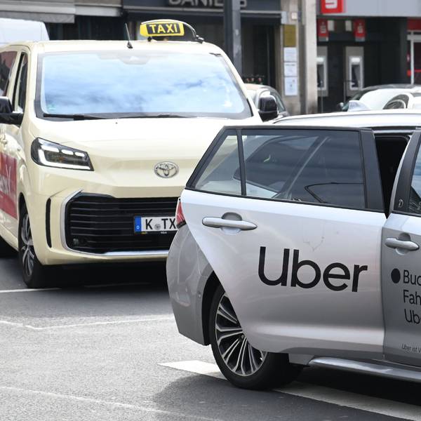 Ein Uber-Fahrzeug nimmt am Kölner Neumarkt einen Fahrgast auf (Archivbild).