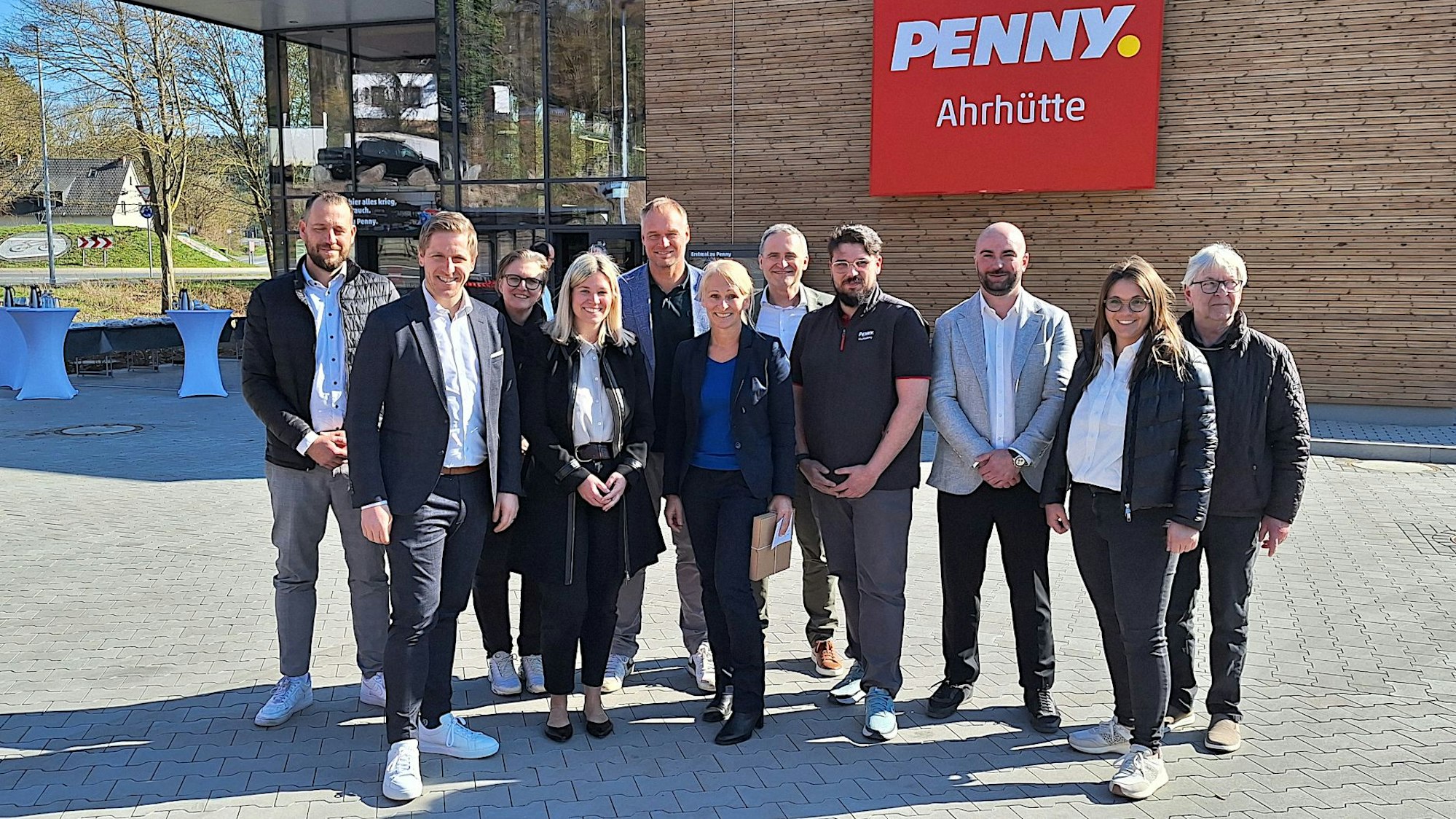 Eine Gruppe von Menschen steht vor dem neuen Penny-Markt in Ahrhütte.