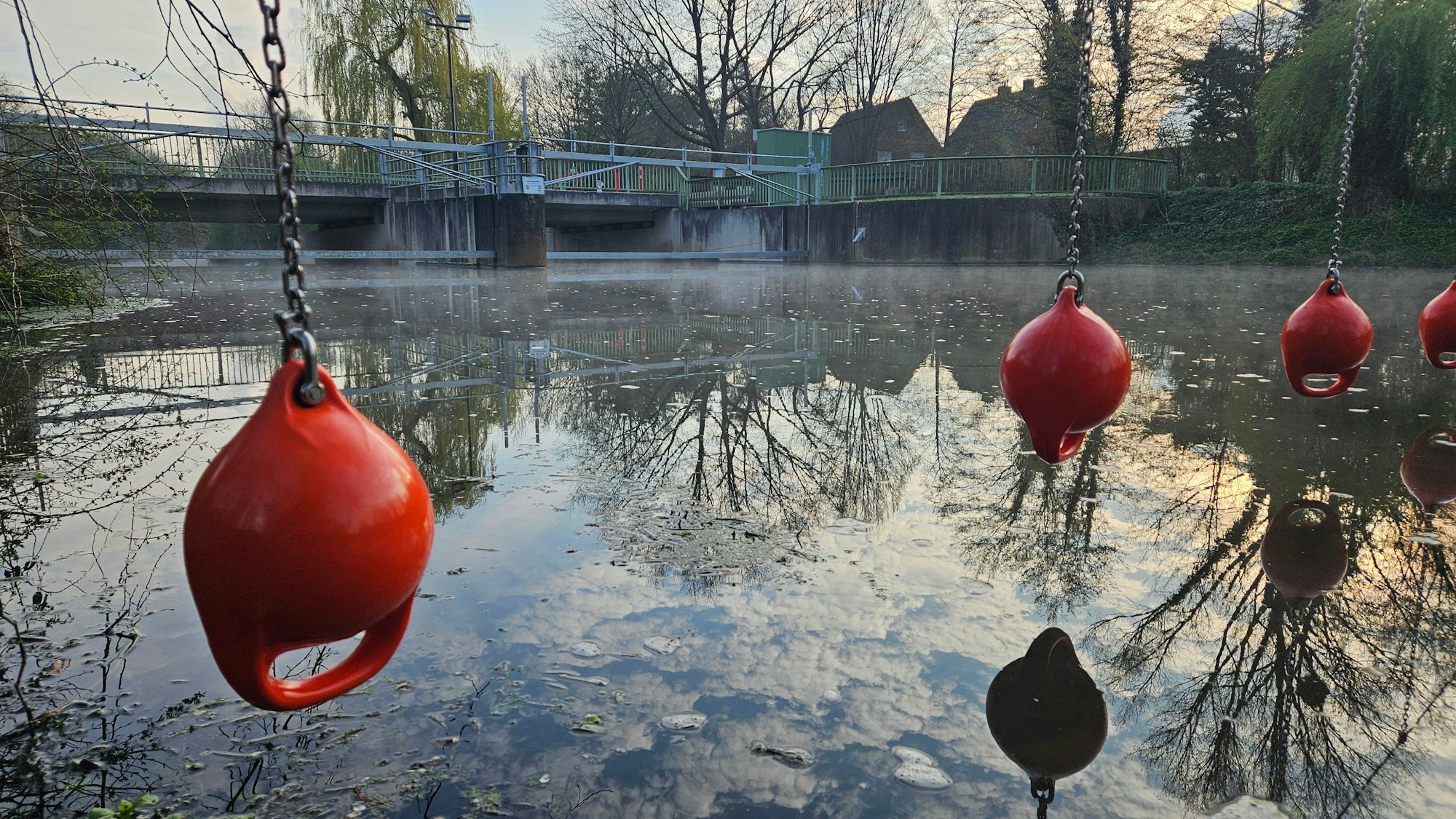 Die Erft in Bedburg: Im Hintergrund ein Wehr, im Vordergrund Rettungsbojen.