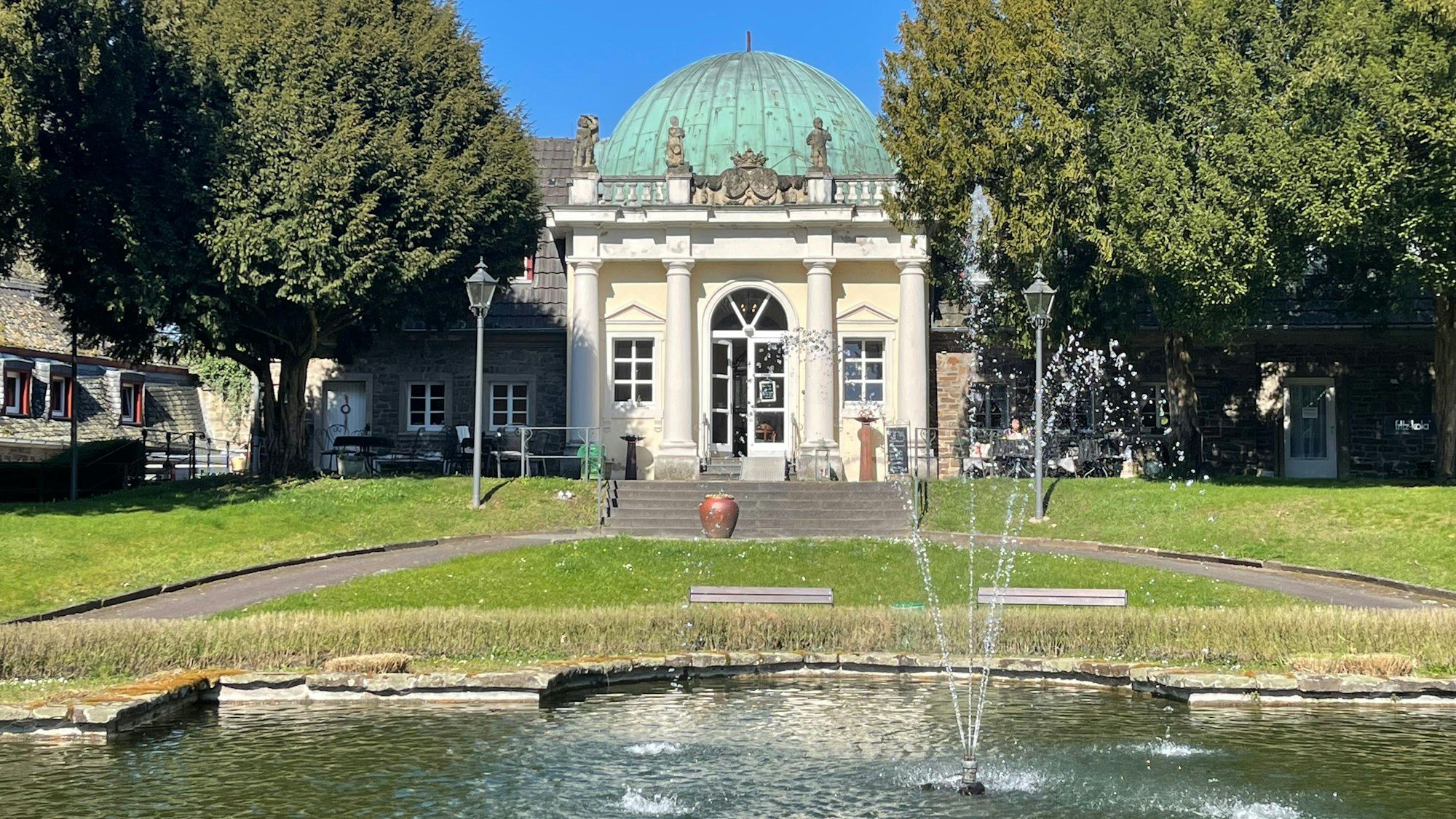 1909 wurde die neobarocke Orangerie von Schloss Merten errichtet, in der seit 2025 die Zuckerbäckerei beheimatet ist.