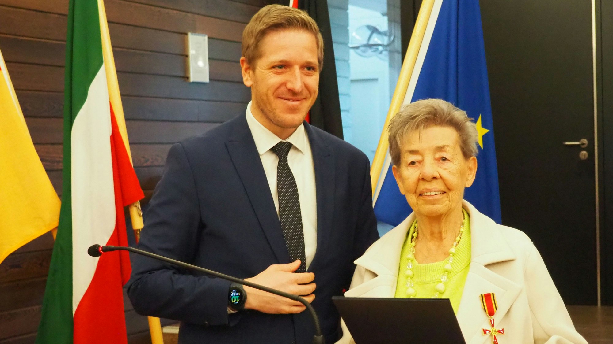 Landrat Markus Ramers (l.) und Inge Lemke sthen hinter einemRednerpult. Sie hält eine Mappe in der Hand.