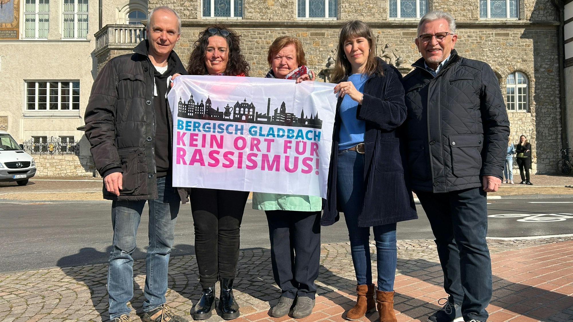 Fünf Vertreter der Stadt halten die Fahne in die Kamera.