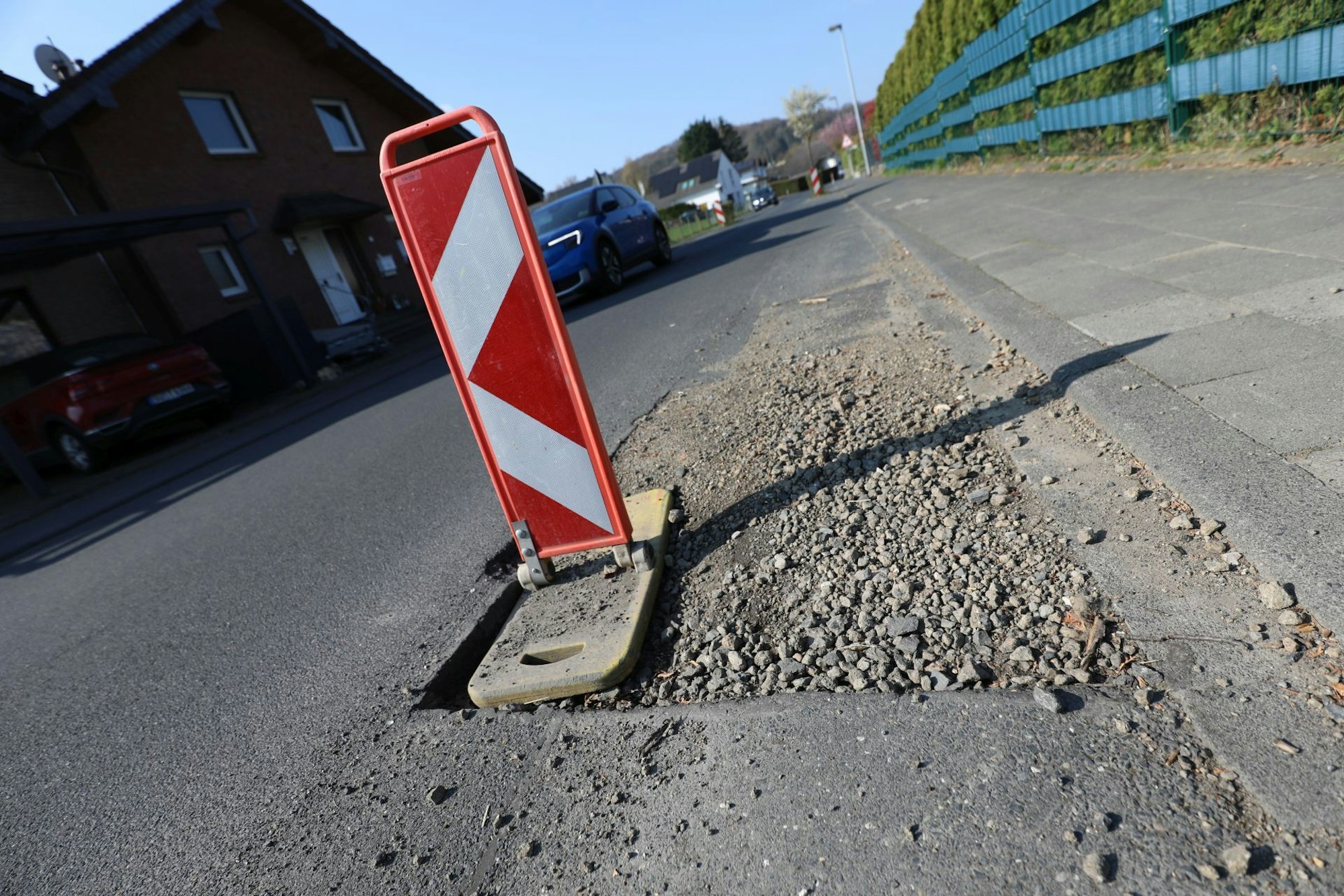 Rosenaustraße in Königswinter-Thomasberg: Nachdem es hier mal eine Baustelle gab, tut sich seit Wochen nichts. Das Loch ist jedoch mit einer Warnbake gesichert.