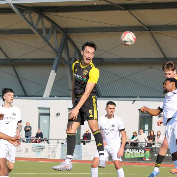 Mehrere Spieler versuchen, den Ball mit dem Kopf zu erreichen, andere beobachten die Szene..
