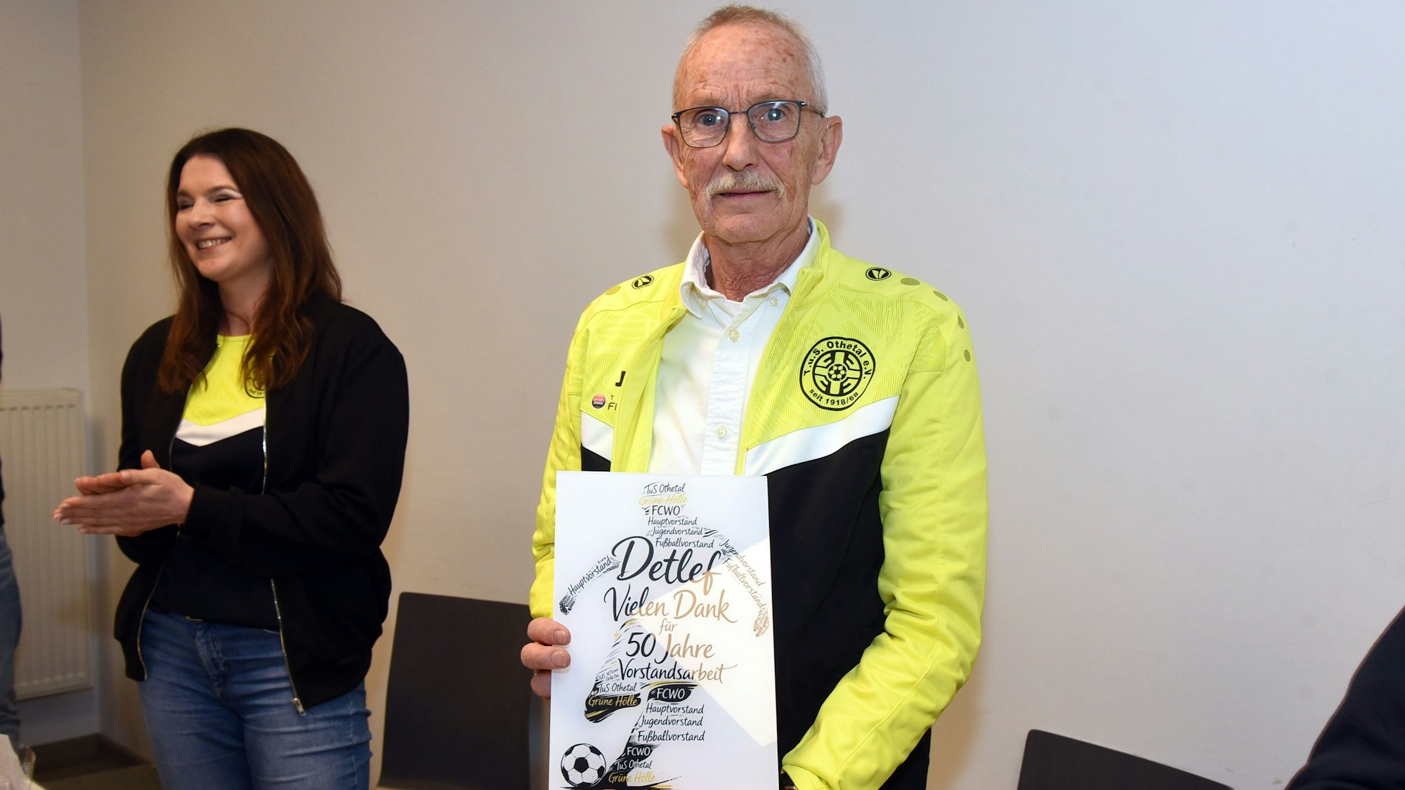 Bild eines Mannes, der eine Urkunde in die Kamera zeigt.