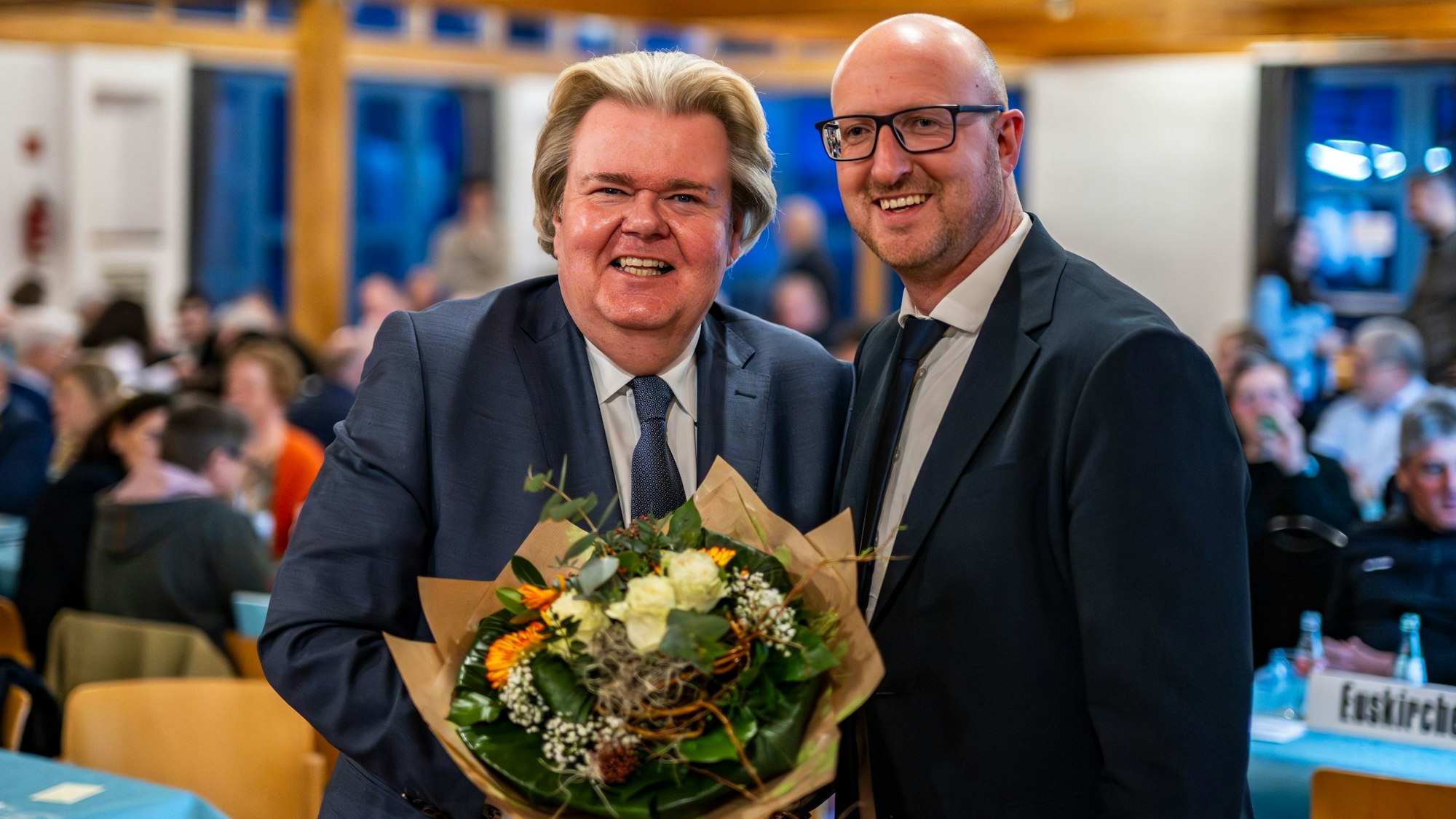 Klaus Voussem und Ingo Pfennings (r.) stehen nebeneinander. Voussem hält einen Blumenstrauß.
