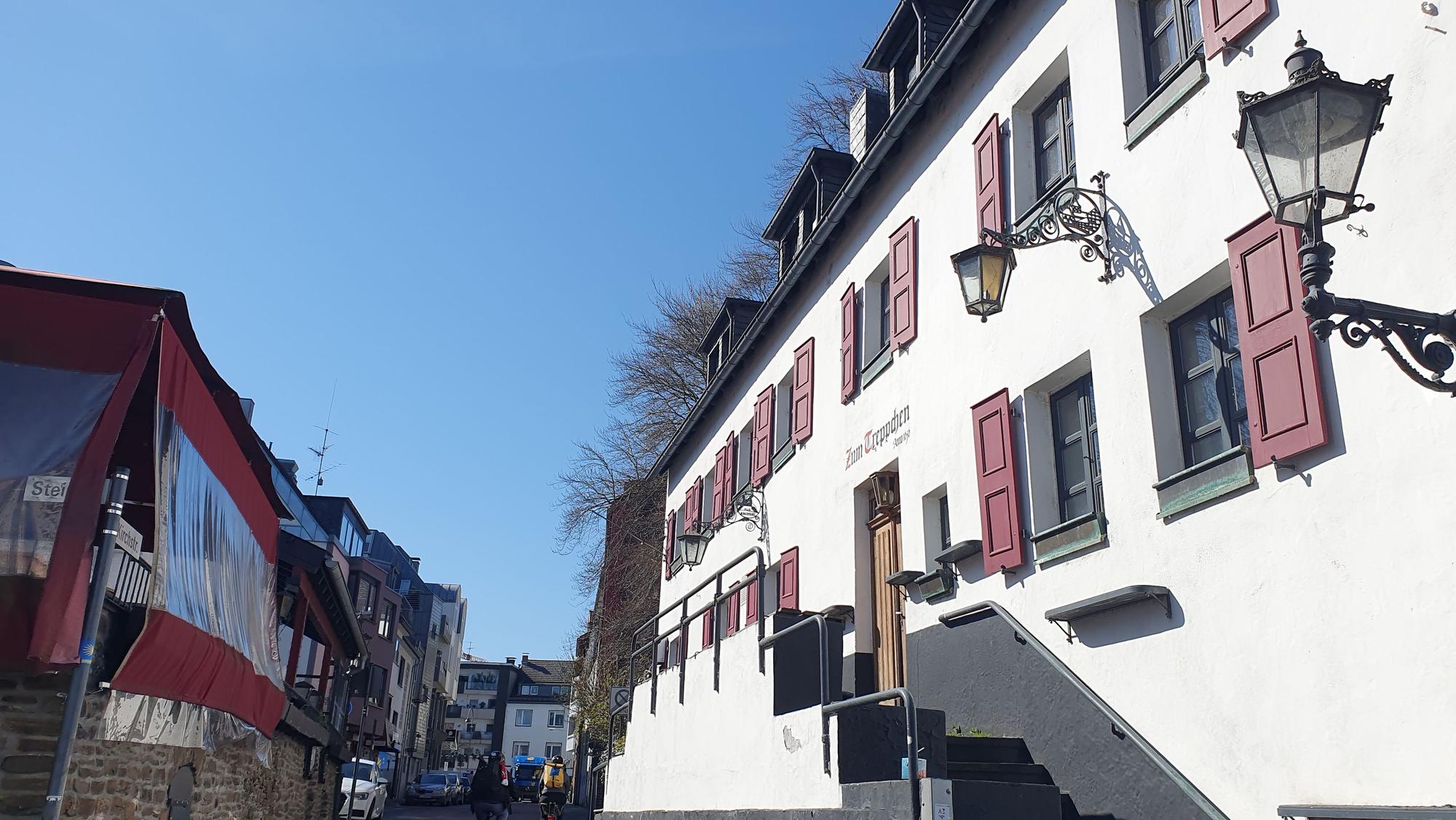 Ein großes altes Haus mit roten Fensterläden ist zu sehen.