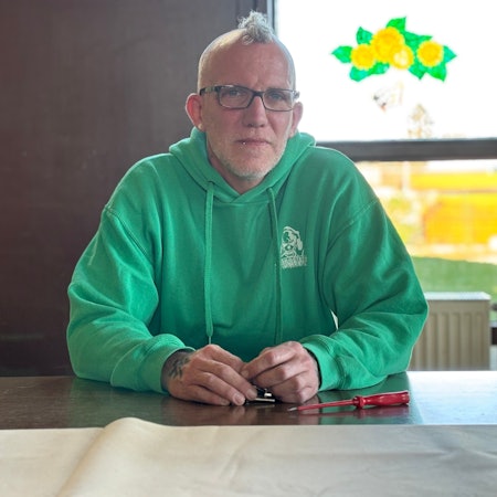 Martin Oertel trägt Brille, Hoodie und Iro. Er sitzt in einem Raum und wird von natürlichem Licht angeleuchtet.