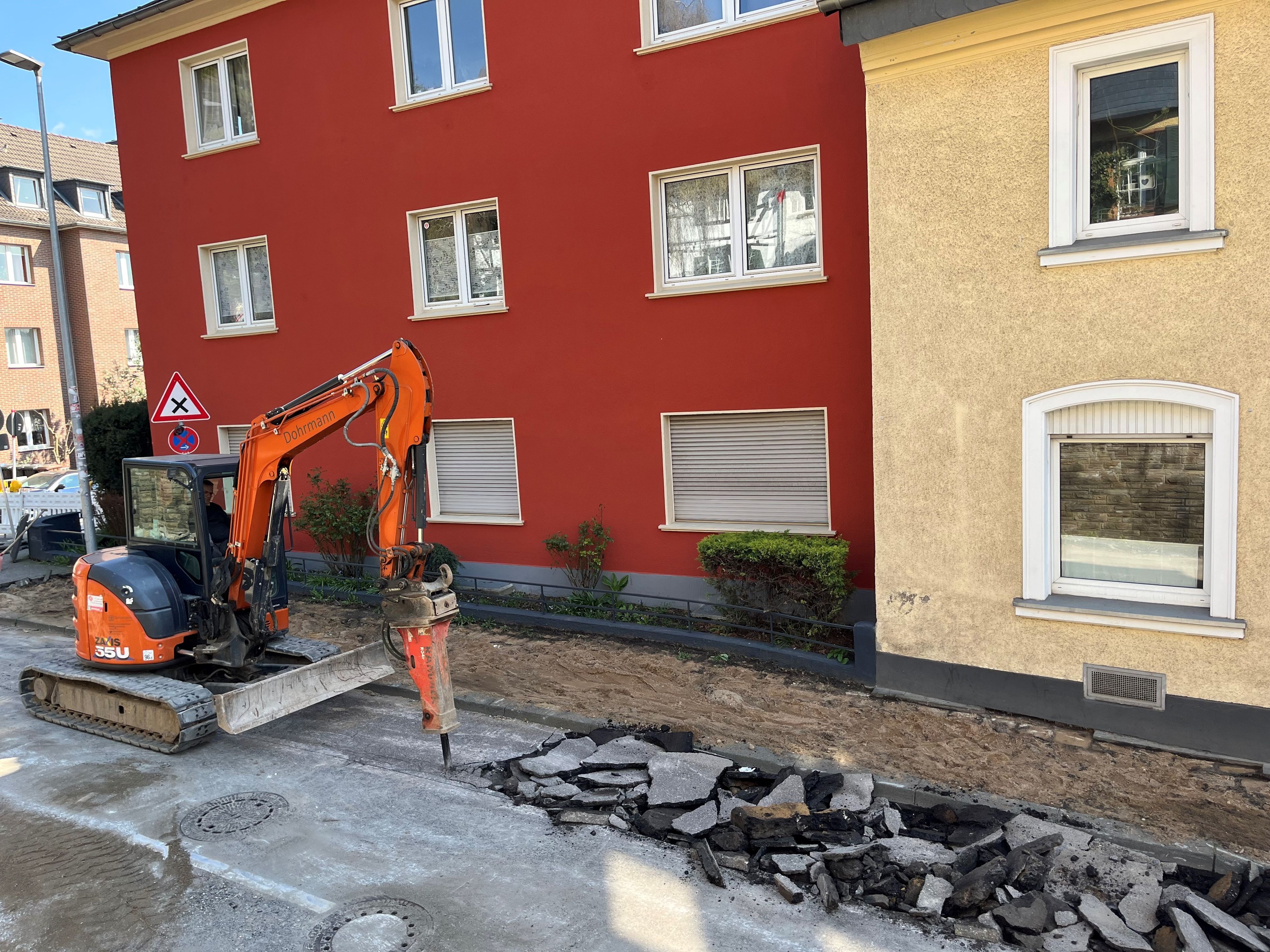 Ein Bagger stemmt die Straße auf.
