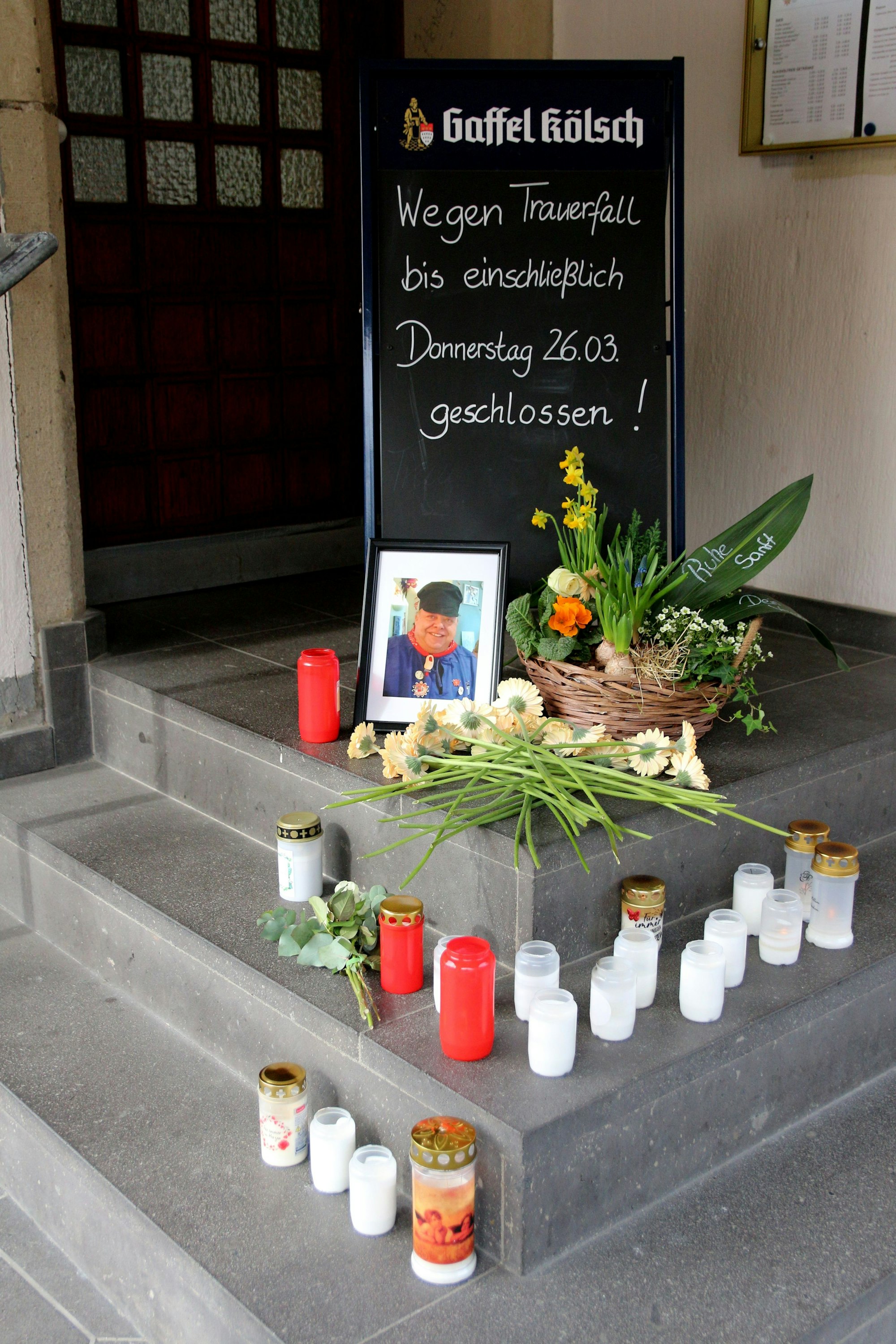 Auf den Stufen zu Müllers Gaststätte wurden Blumen abgelegt und Kerzen aufgestellt. Ein Foto zeigt den Verstorbenen.