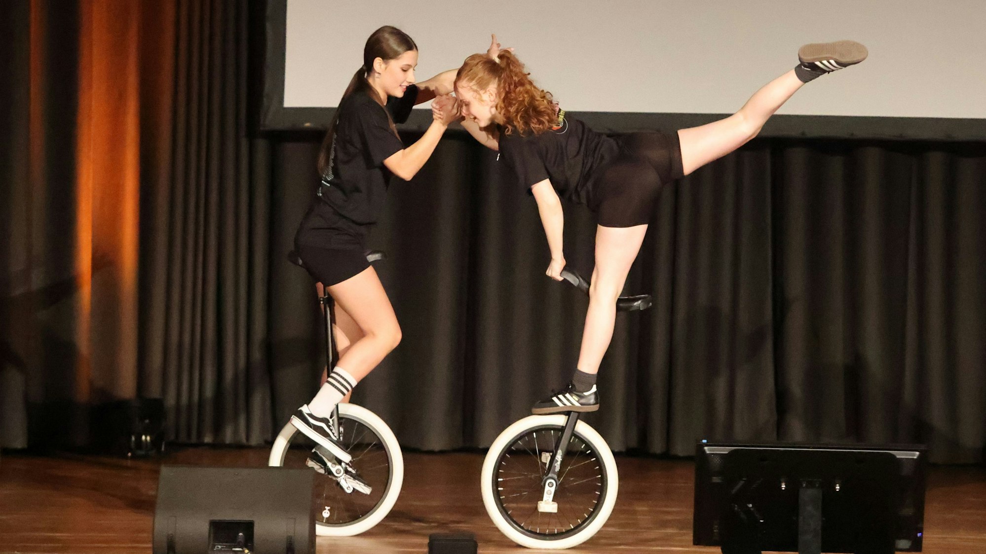 Zu sehen sind zwei junge Frauen auf Einrädern