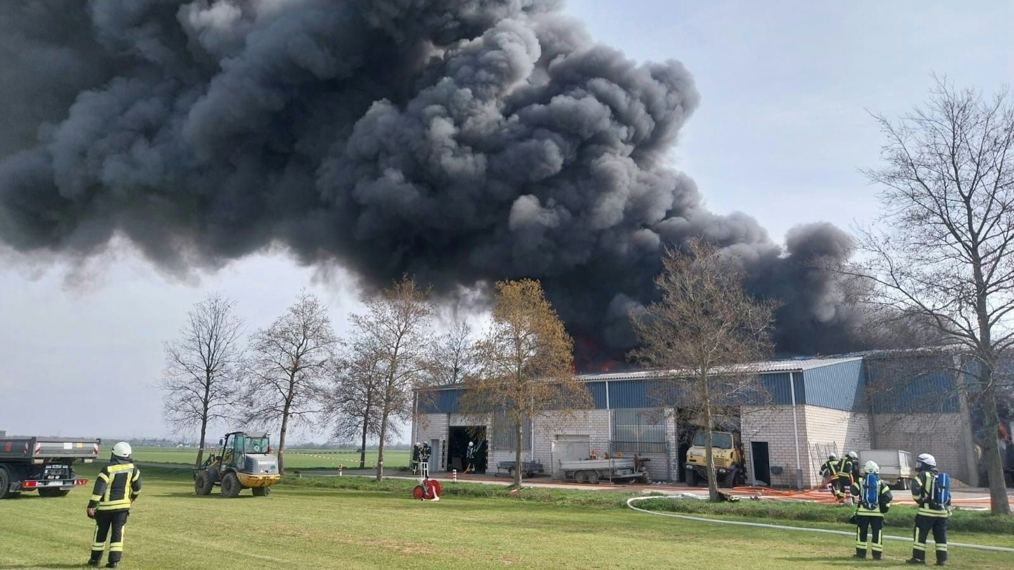 Großbrand in Niederkassel-Rheidt: Dicke Rauchwolken über einer Lagerhalle.