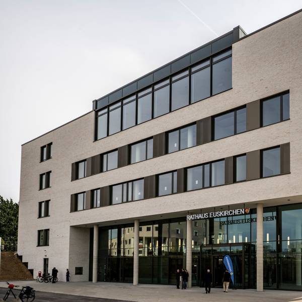 Das neue Rathaus hat eine helle Fassade und im Erdgeschoss eine gläserne Front.