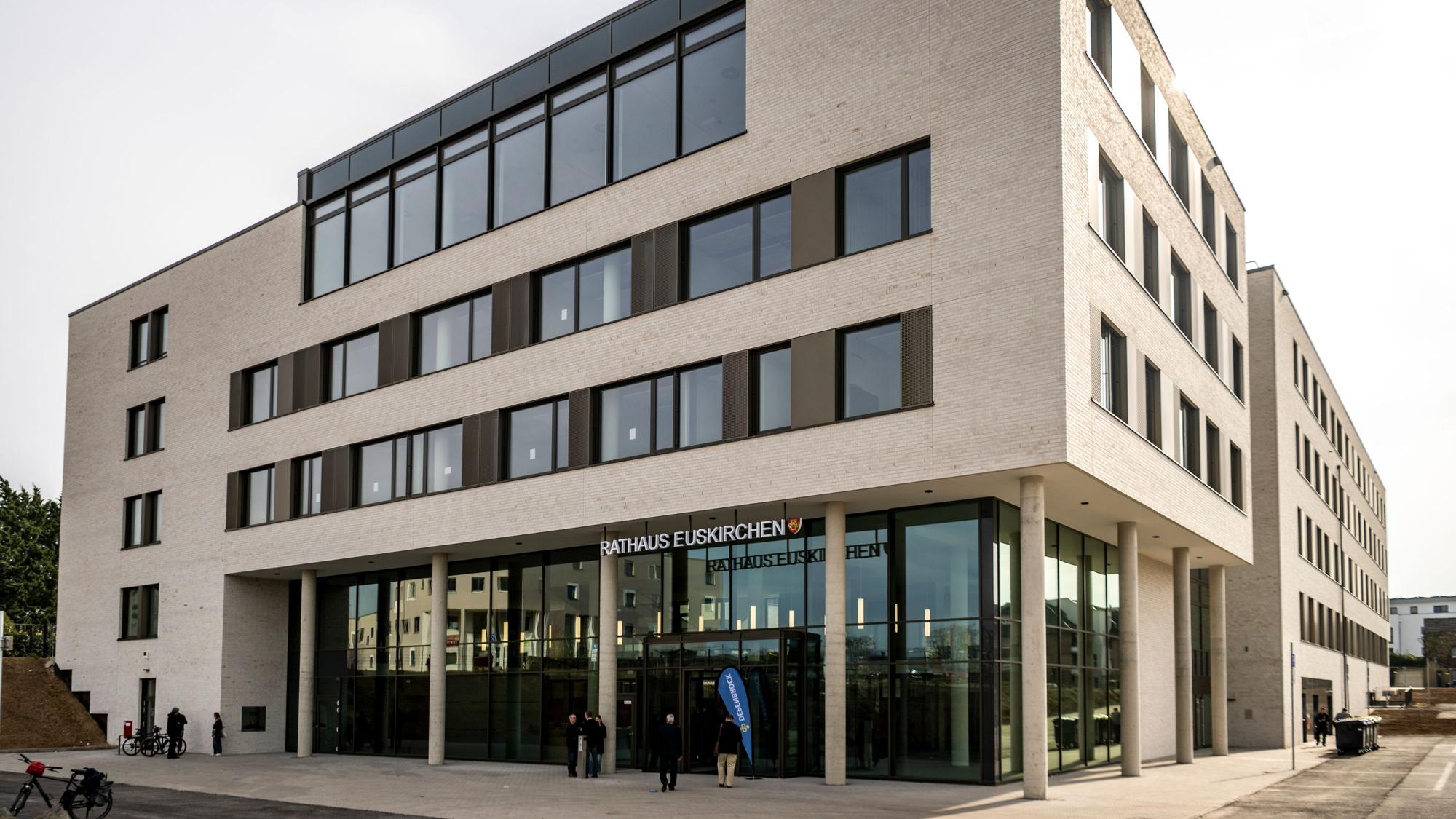 Das neue Rathaus hat eine helle Fassade und im Erdgeschoss eine gläserne Front.