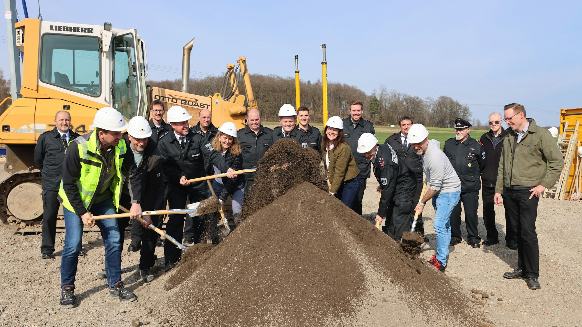 Das Gruppenfoto zeigt Menschen beim ersten Spatenstich für das Feuerwehrgerätehaus Heide.