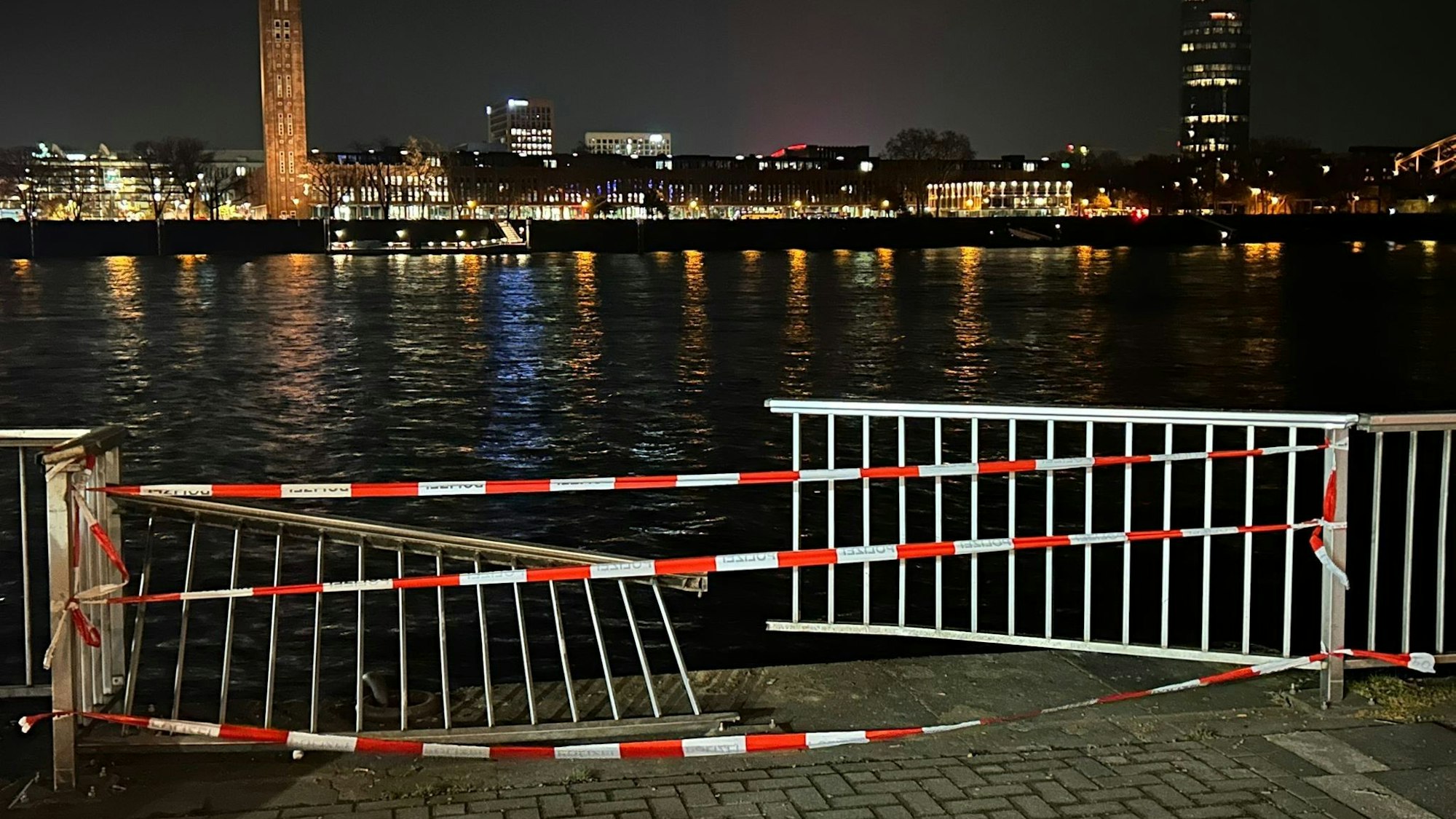 Auf dem Bild ist die Absperrung zu sehen, nach einem Feuerwehreinsatz, bei dem zwei Menschen aus einem Auto gerettet wurden, das in den Rhein durch das Geländer gefahren und untergangen ist.
