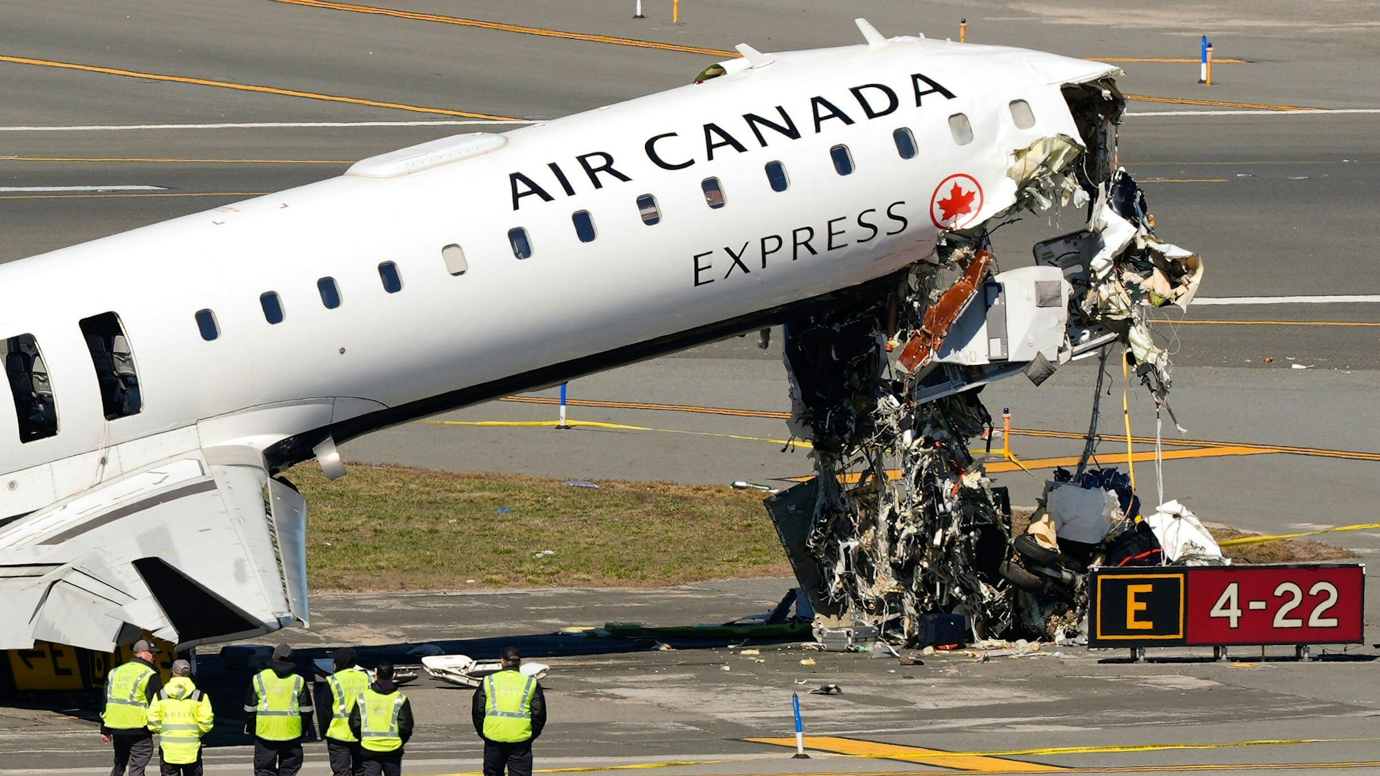 Mitarbeiter der Flugzeugwartung inspizieren das Wrack eines Air-Canada-Express-Jets, der am Sonntagabend auf dem Flughafen LaGuardia mit einem Feuerwehrauto der Hafenbehörde zusammengestoßen war. (Archivbild)