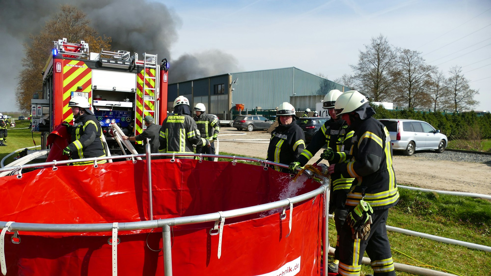 Schwierig war die Wasserversorgung vor Ort. Landwirte und die Tnklaster der Hennefer Feuerwehr brachten Wasser, das in große Behälter gefüllt wurde, um daraus die brennende Halle zu löschen.