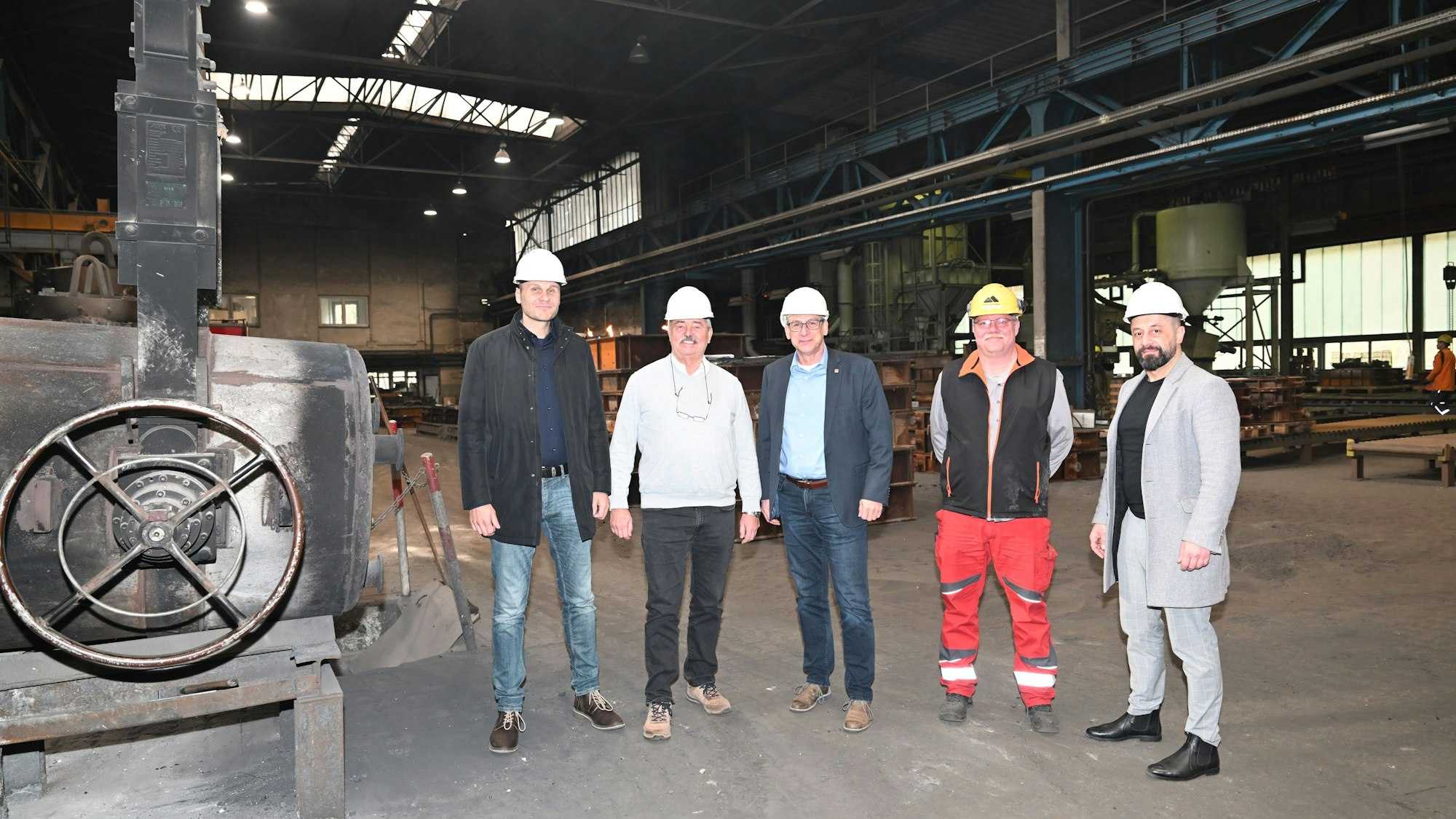 IG Metall-Bezirksleiter Knut Giesler besucht die insolvente Bergische Edelstahlwerke GmbH. Auf dem Bild (v.l.) stehen Insolvenzverwalter Martin Plappert, Geschäftsführer Georg Wanders, IG Metall-Bezirksleiter Knut Giesler, Betriebsrat Michael van der Werf und Gewerkschaftssekretär Haydar Tokmak in einer Produktionshalle.