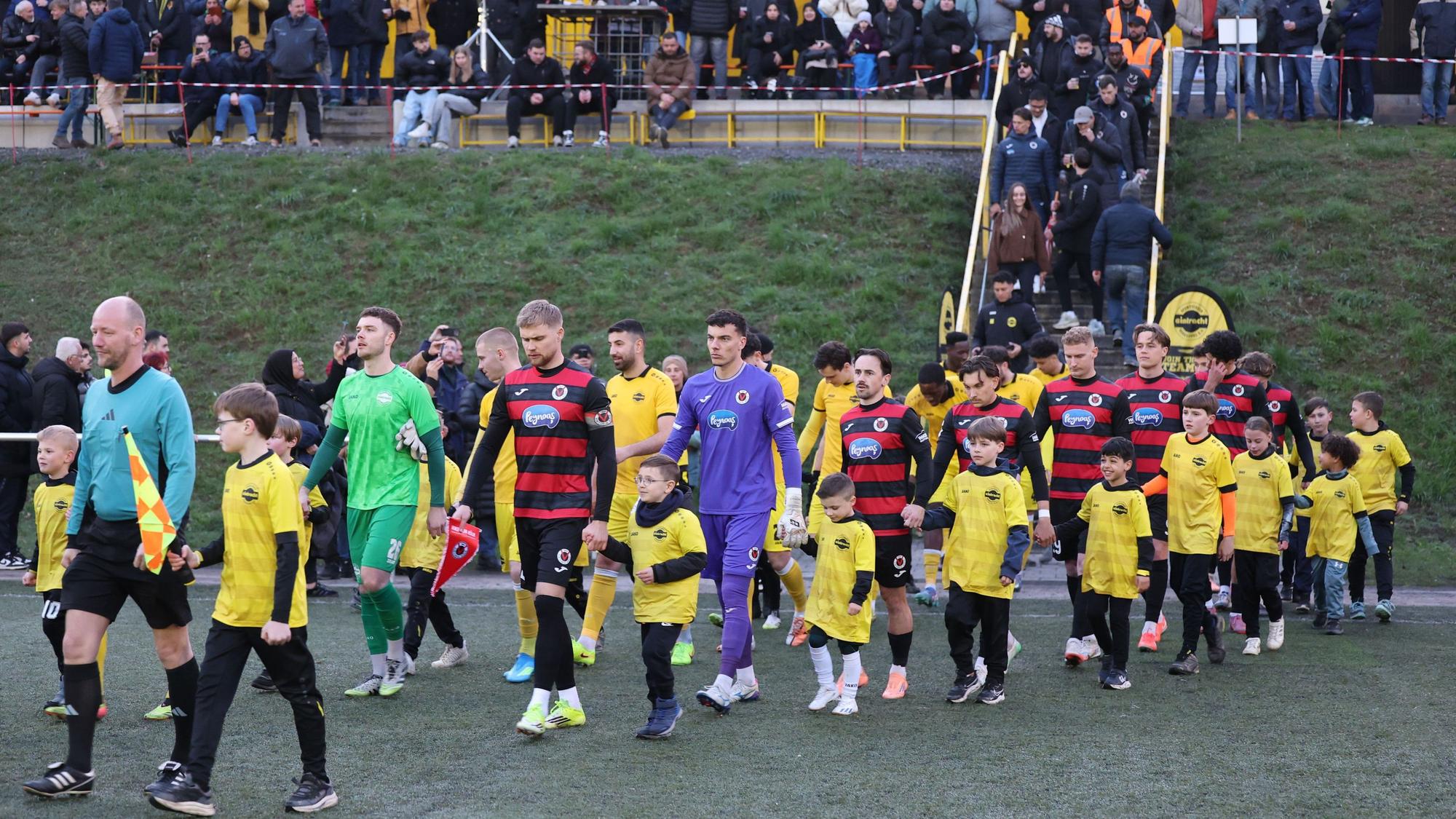 Die beiden Mannschaften laufen mit den Nachwuchskicker ins Achim-Lammers-Stadion in Köttingen ein.