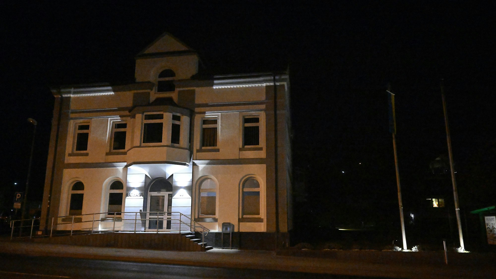 Zu sehen ist das beleuchtete Rathaus von Overath am Abend.