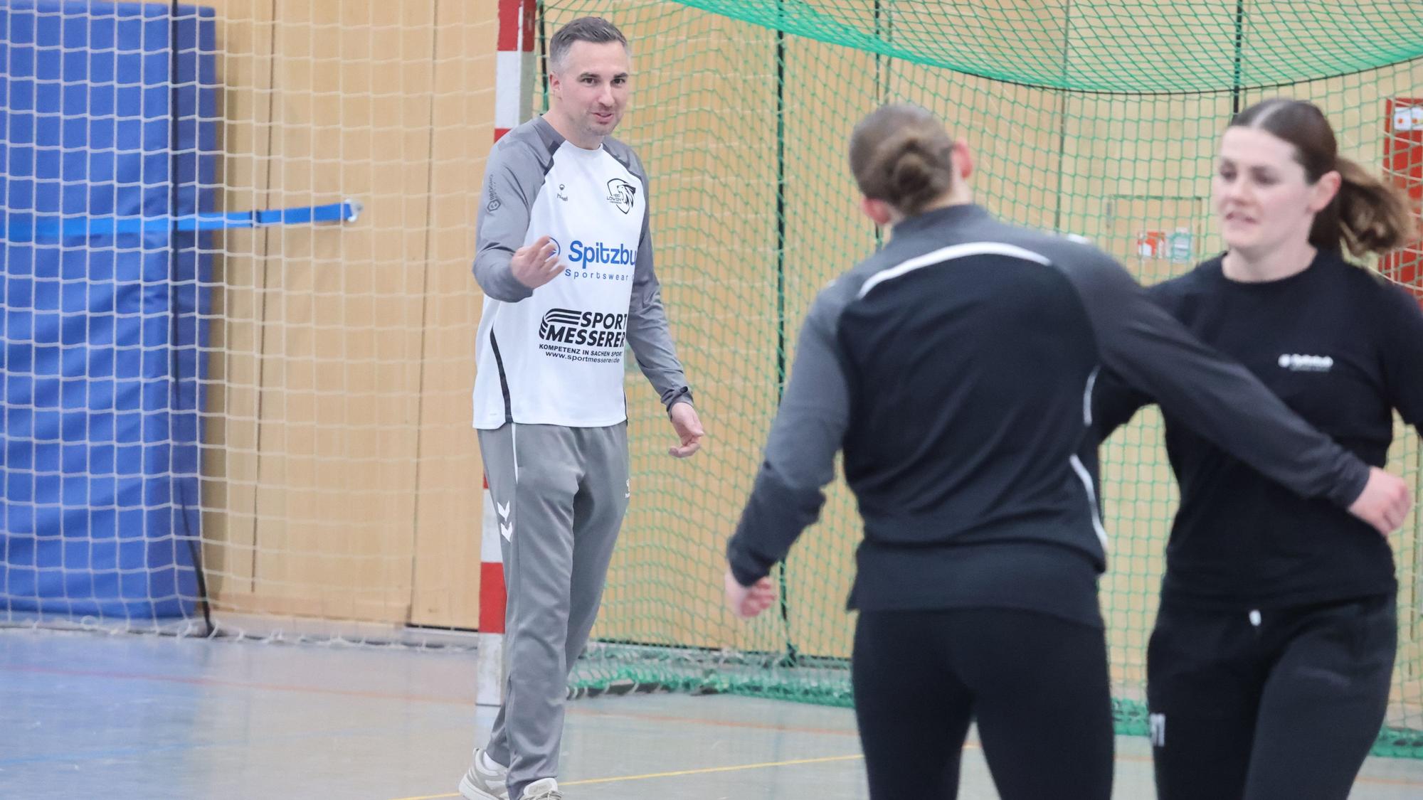 Handball-Trainer Dennis Hermann in Aktion in einer Sporthalle.