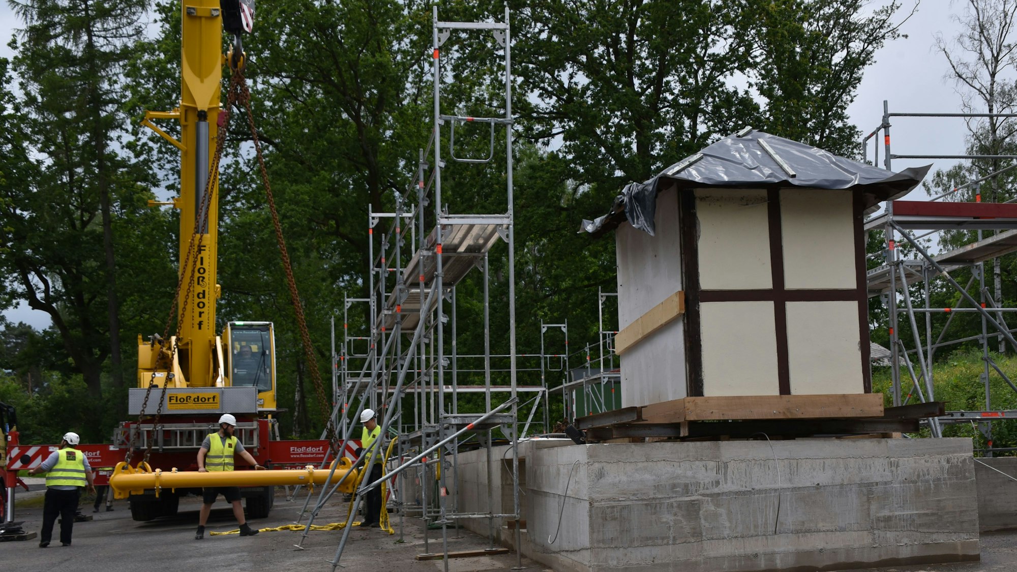 Das alte Bahnhofshäuschen steht schon auf seinem Sockel, umgeben vor Gerüsten und einem Kran.