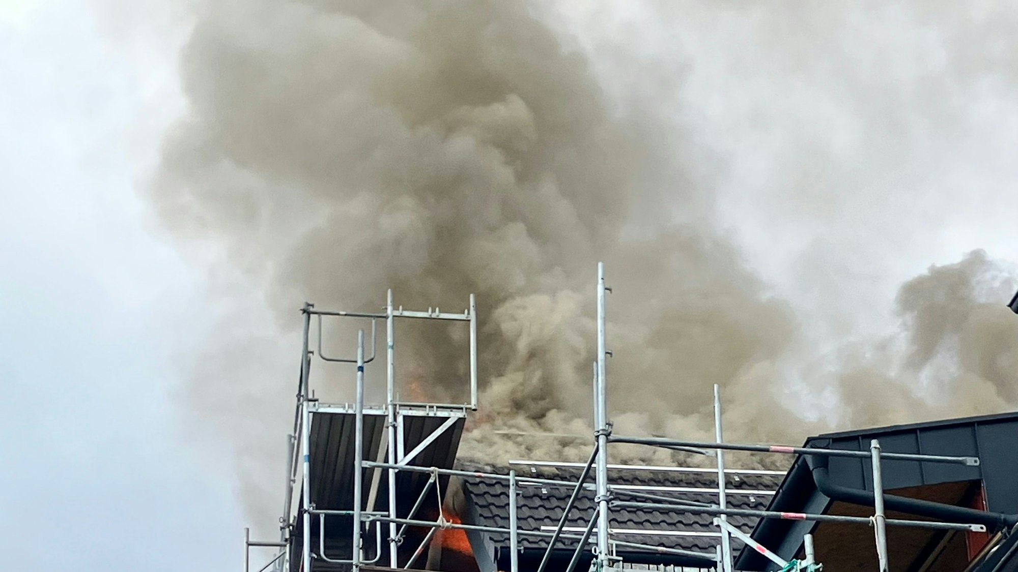 Aus dem Dach eines Hauses steigen Rauchwolken auf.