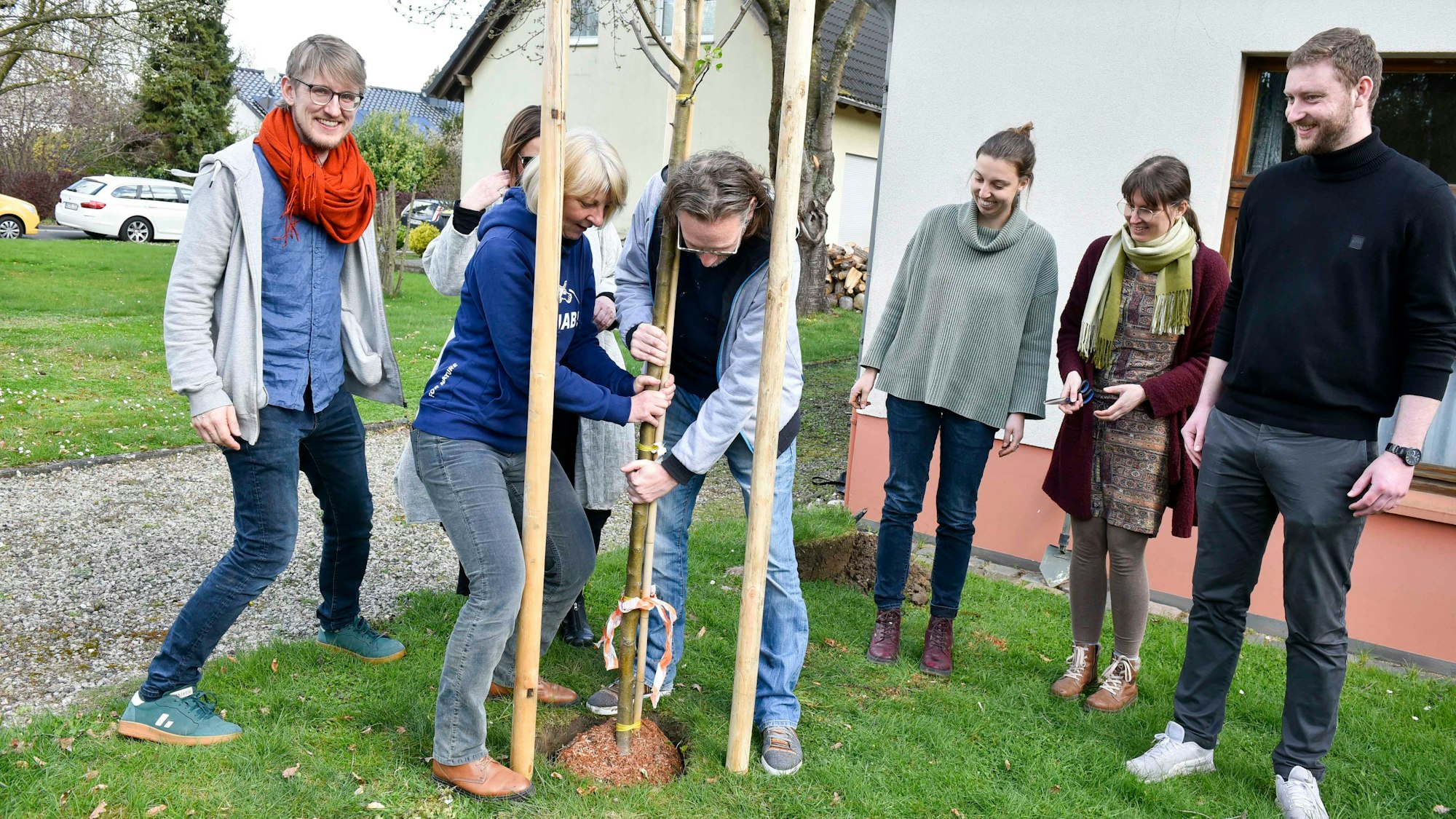 Das Foto zeigt Menschen beim Pflanzen eines Baums.