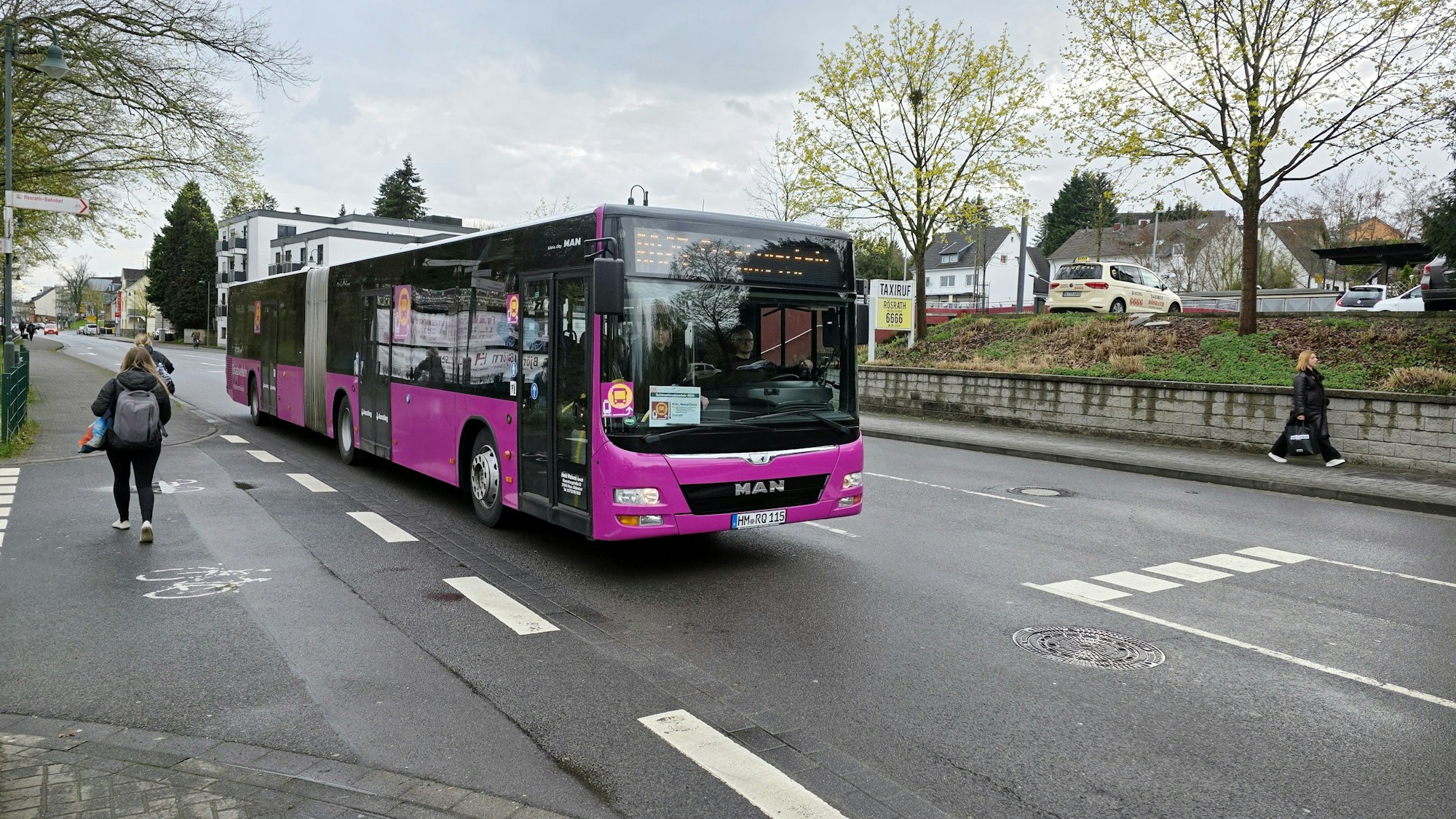 Zu sehen ist ein violetter Bus bei der Fahrt.