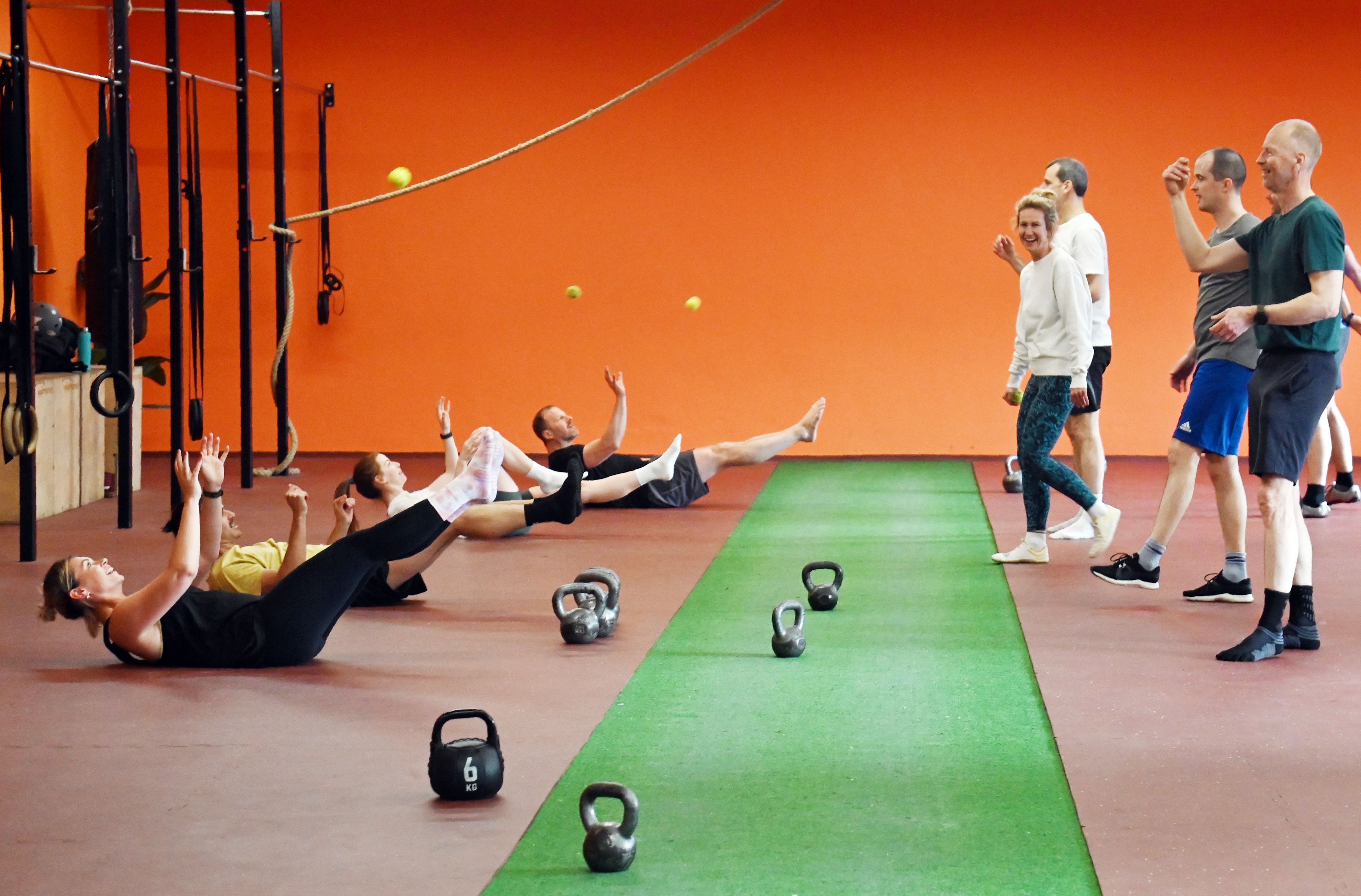 Diese Übung ist ein Mix aus Teamwork, Rumpftraining und Hand-Auge-Koordination: Während ein Partner den Ball zuwirft, hält der andere die Bootspose, fängt den Ball und liest den Buchstaben zwischen den Fingern ab.