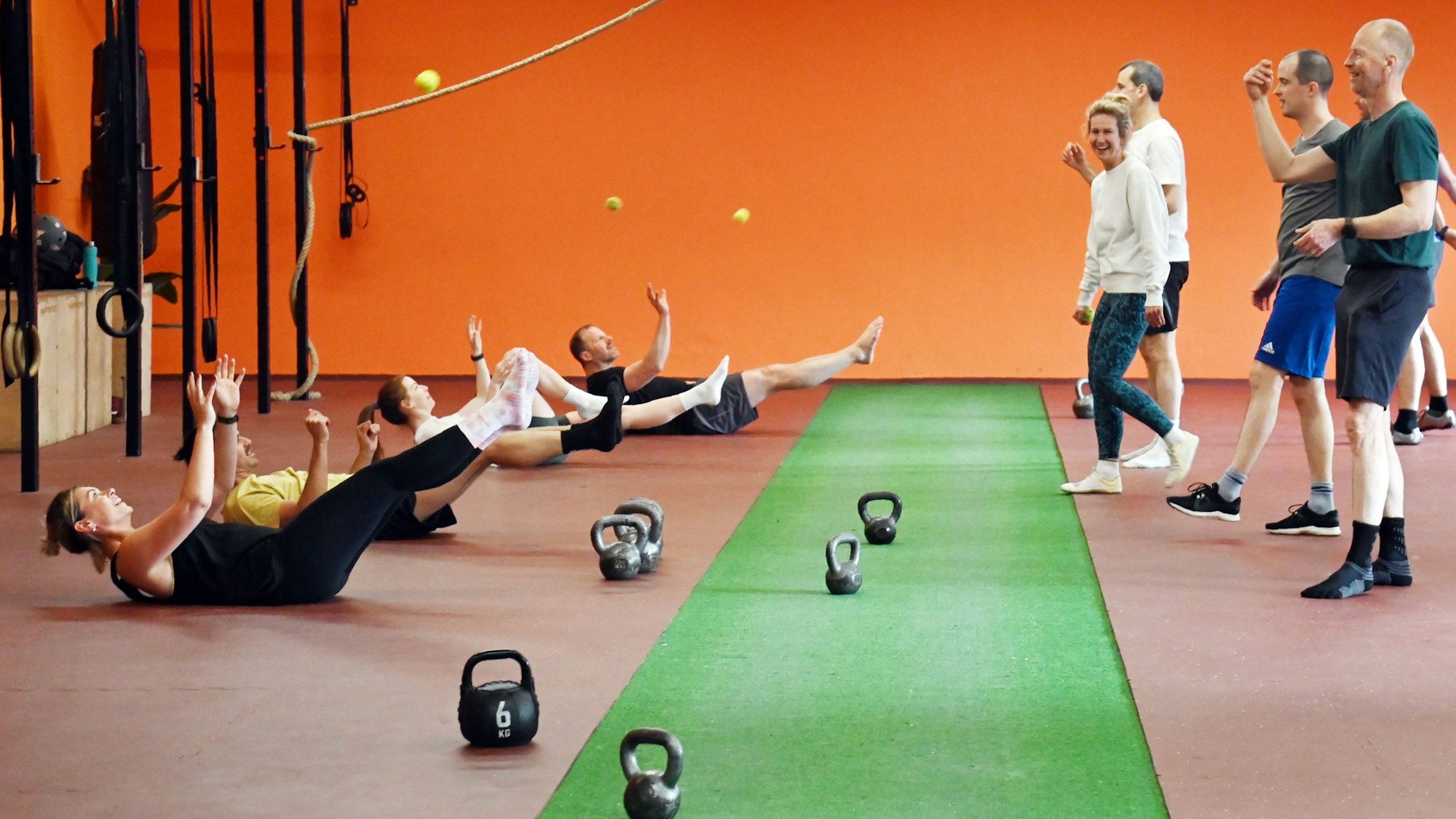 Diese Übung ist ein Mix aus Teamwork, Rumpftraining und Hand-Auge-Koordination: Während ein Partner den Ball zuwirft, hält der andere die Bootspose, fängt den Ball und liest den Buchstaben zwischen den Fingern ab.