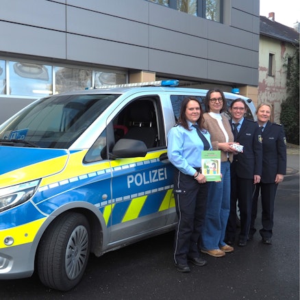 Die vier Frauen stehen an einem Streifenwagen.
