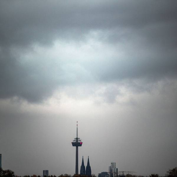 Wolken ziehen am Morgen über den Kölner Dom und den Fernsehturm.