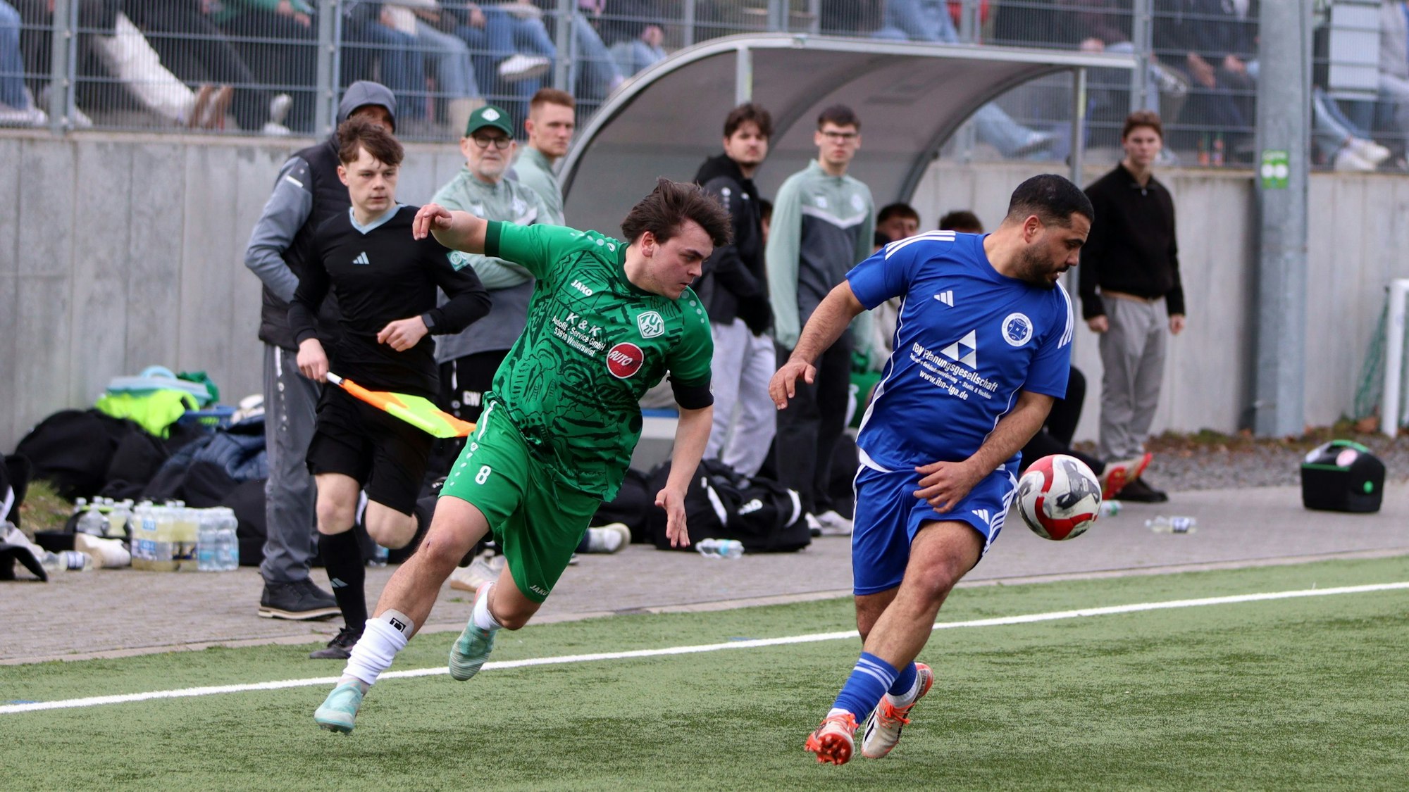 Zwei Fußballer laufen nach vorne, blicken aber zurück, weil sich der Ball hinter ihnen befindet.