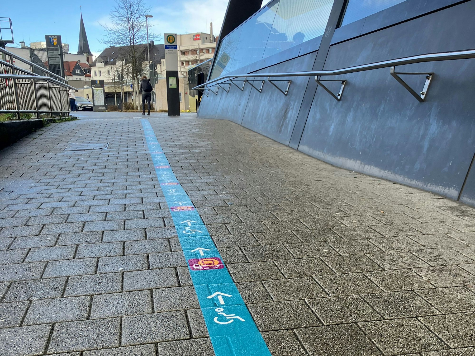 In Gummersbach weist eine hellblaue auf den Boden geklebte Linie mit Pfeilen den Weg vom Bahnsteig in Richtung Ersatzhaltestelle am Busbahnhof.