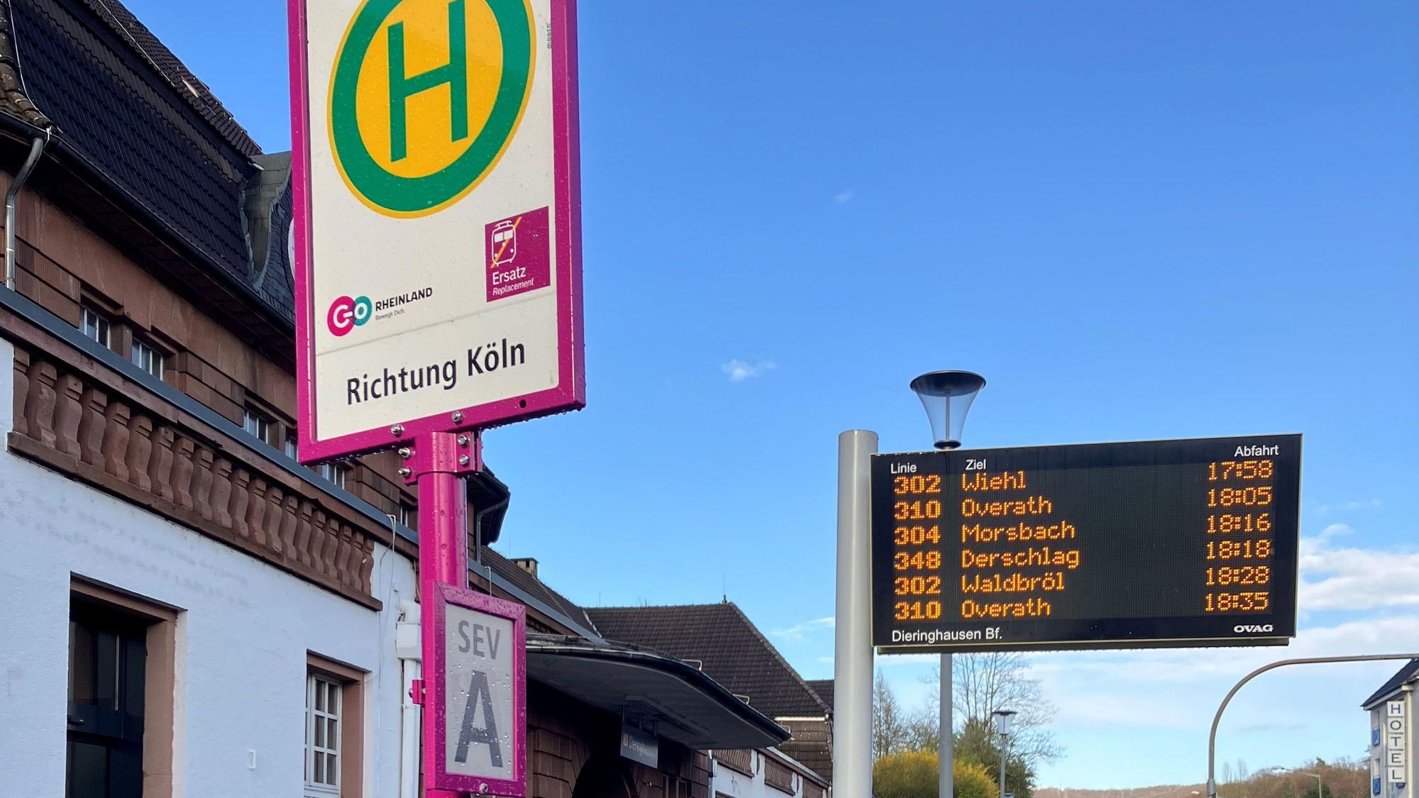 Ein Bushaltenstellenschild und eine elektronische Anzeige.